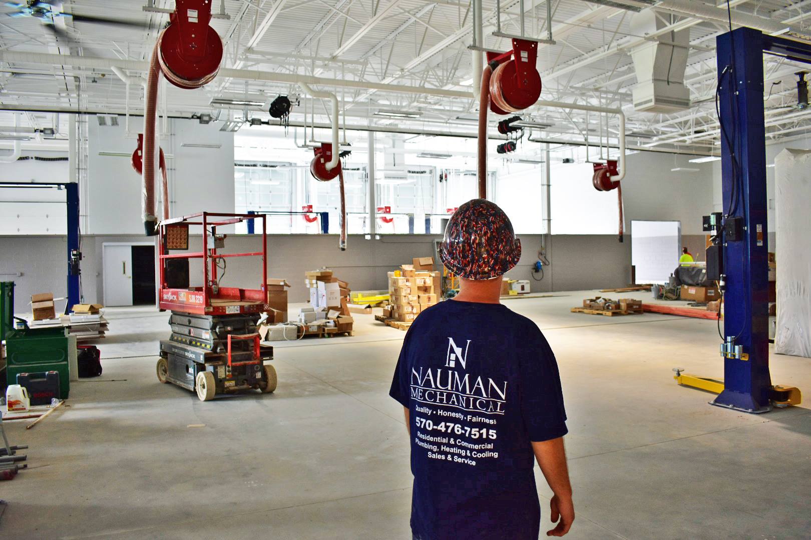 A man in a blue shirt is standing in a large room.