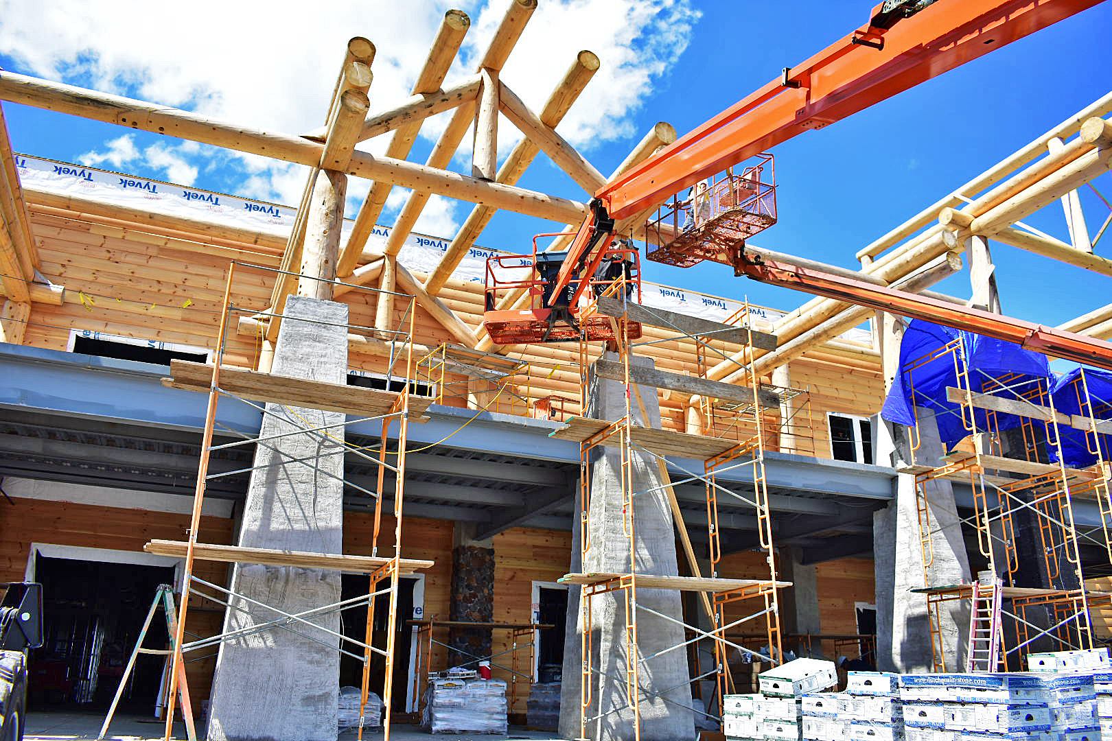 A large building is being built with scaffolding and a crane.