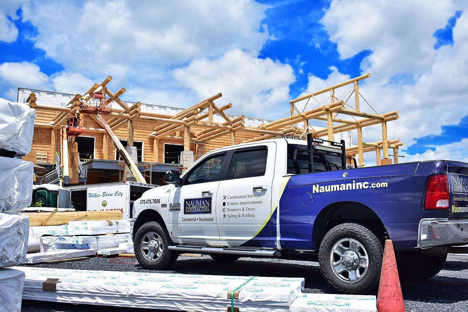A Nauman inc. truck is parked in front of a building under construction.