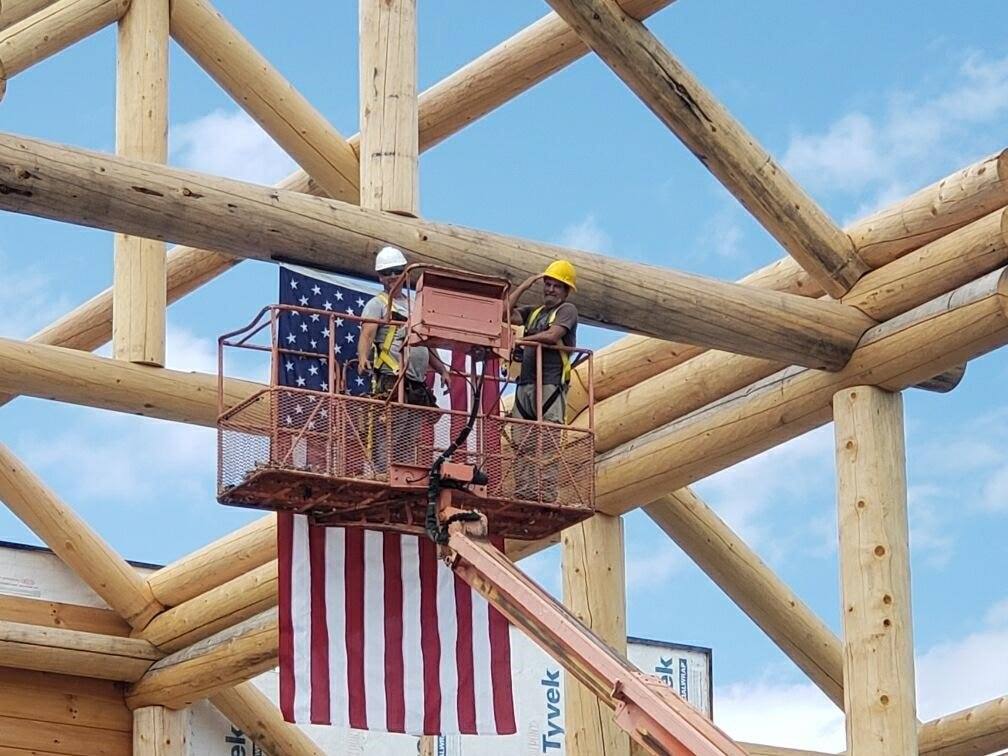 A group of construction workers are working on a wooden structure.