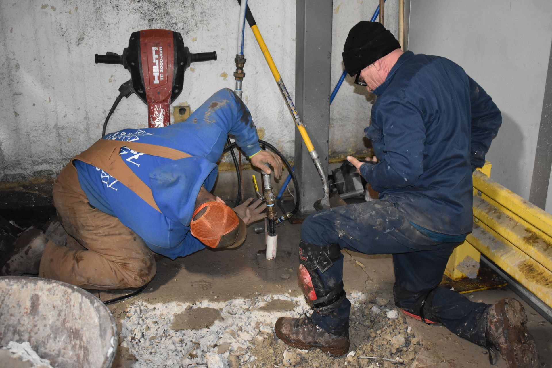 Two men from Nauman Inc. are working on fixing plumbing.