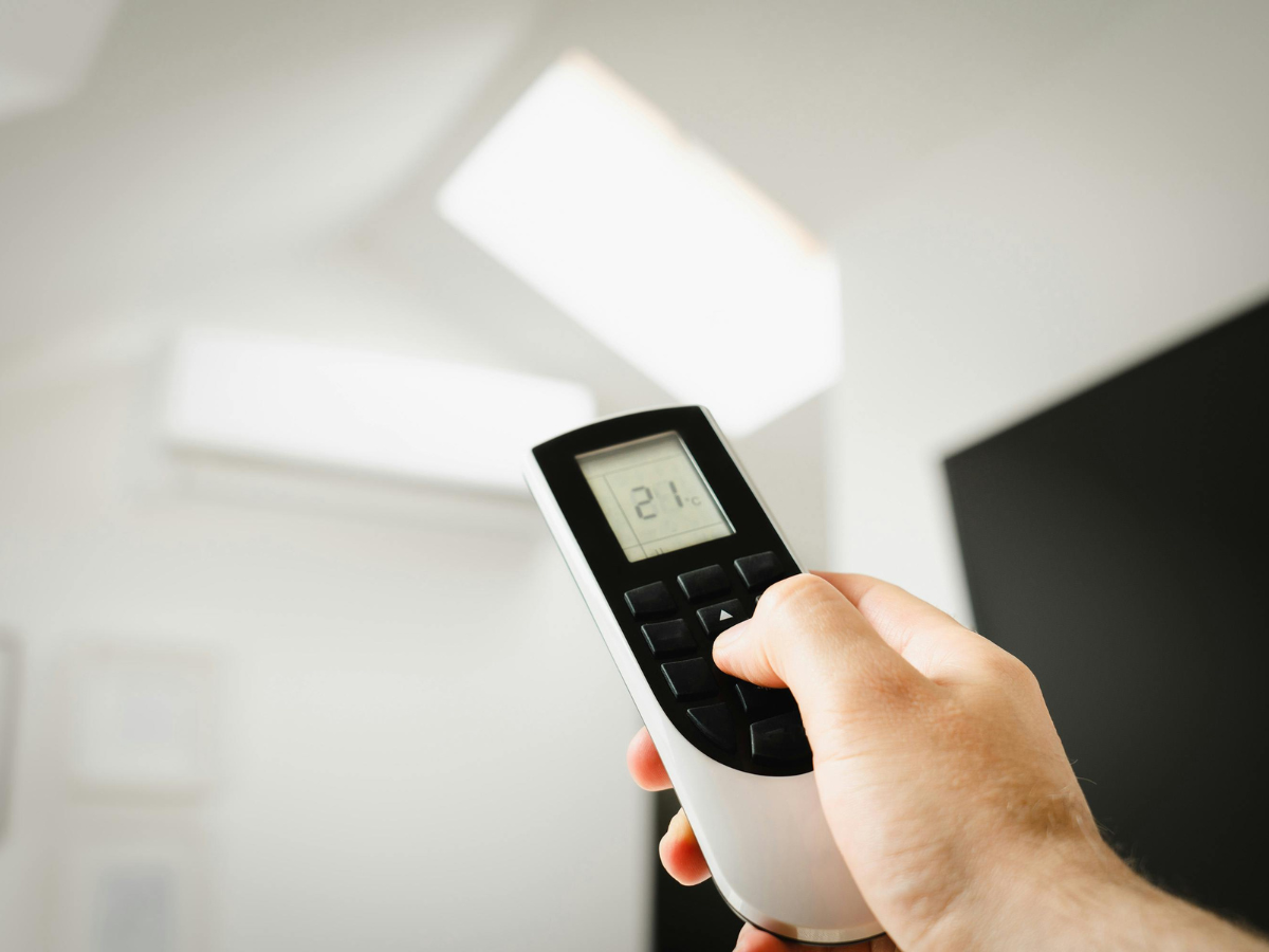 A person is holding a remote control with the number 21 on it A person is holding a remote control with the number 21 on it
