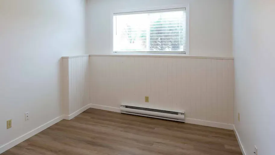 A room with a baseboard heater in it.