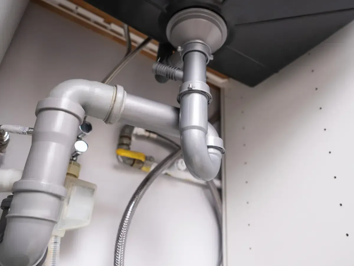 A close up of a pipe under a sink in a kitchen