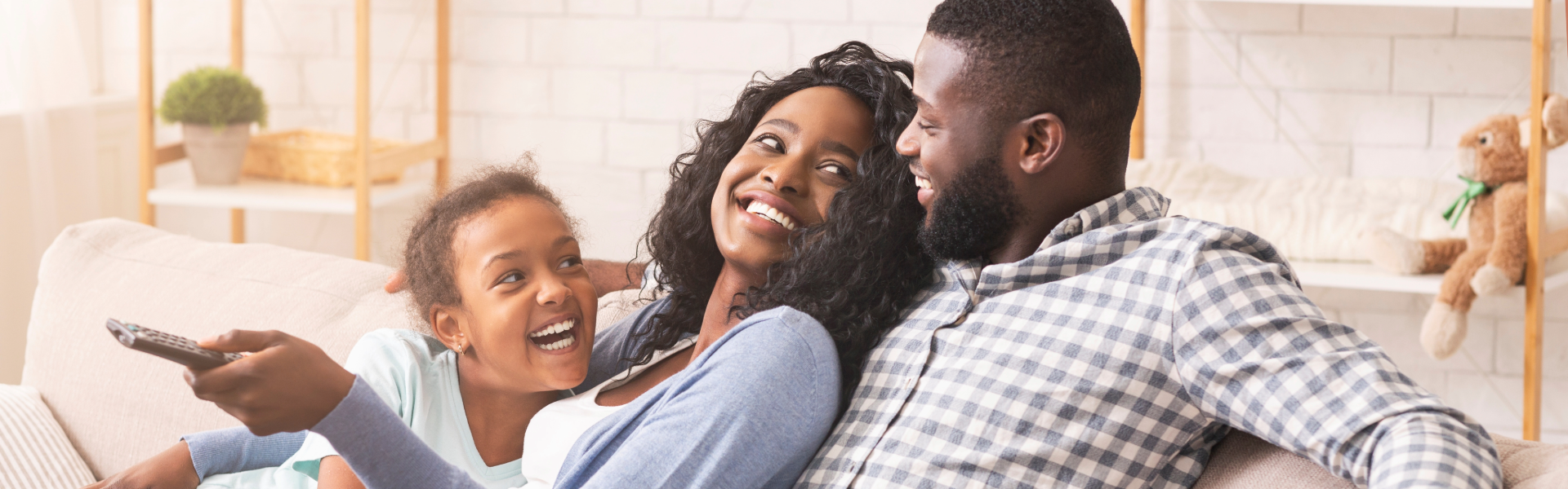 A family sitting on the couch, relaxing.