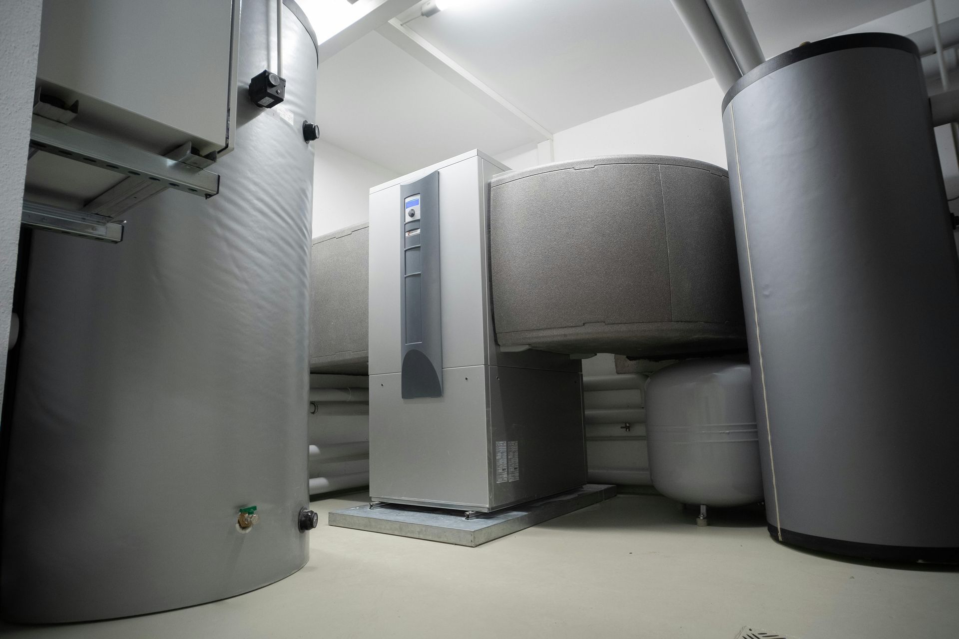 A room with a lot of gray cylinders and a white box on the floor.