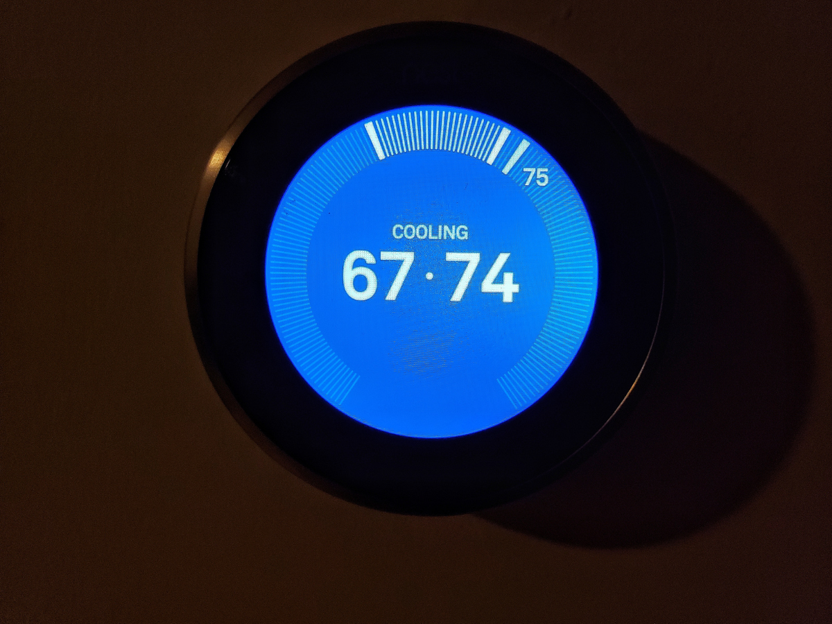 A thermostat displays a temperature of 67-74 degrees