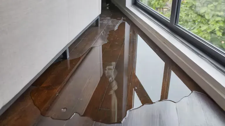 A flooded floor in a room next to a window.