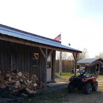 An atv is parked in front of a wooden building