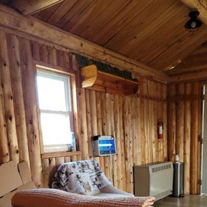 A wooden room with a couch and a window