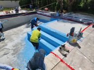 A group of men are working on a swimming pool.