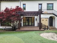 The back of a house with a pergola and a deck