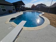 A large swimming pool with a diving board in the middle of it.