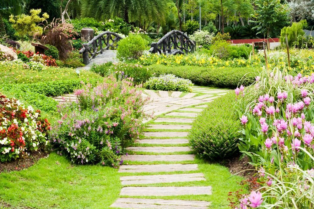 Garden Path Through Lush Green Flowers and Pink Blooms in a Landscaped Garden — Toowoomba Lawn and Yard care In Glenvale, QLD