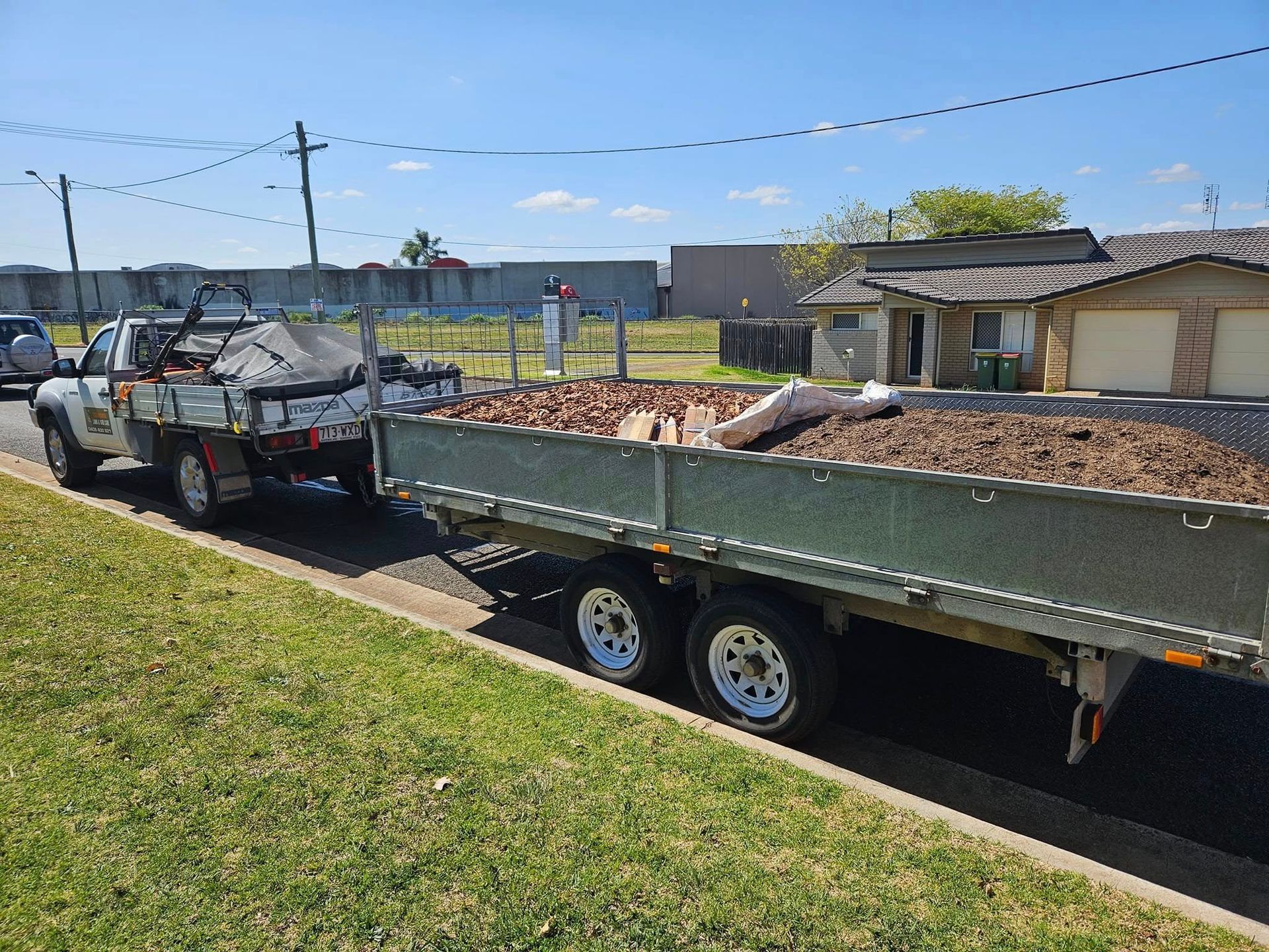 Flatbed Trailer Loaded With Waste, Towed by a Truck — Toowoomba Lawn and Yard care In Glenvale, QLD