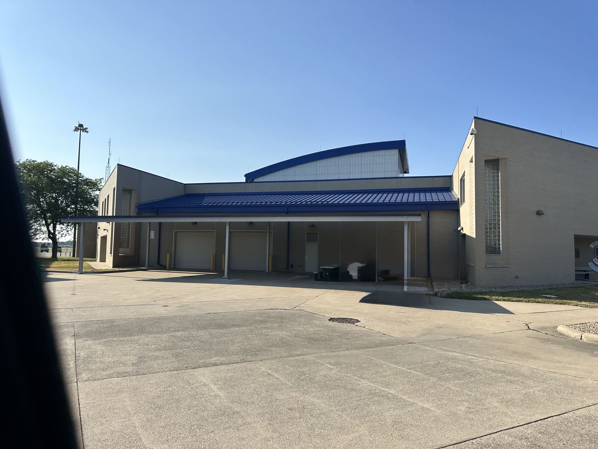 A modern kitchen with sage green cabinets, wood island, and black accents.