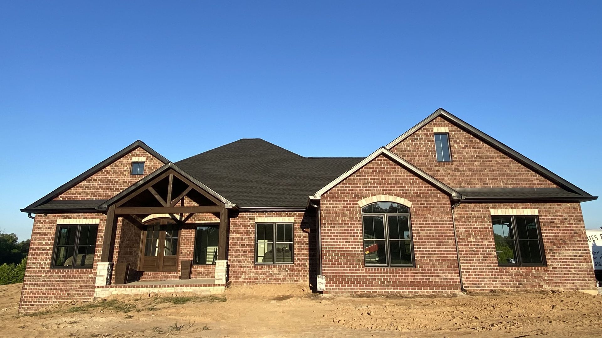 Modern kitchen with sage green cabinets, wooden island, and dark fixtures.