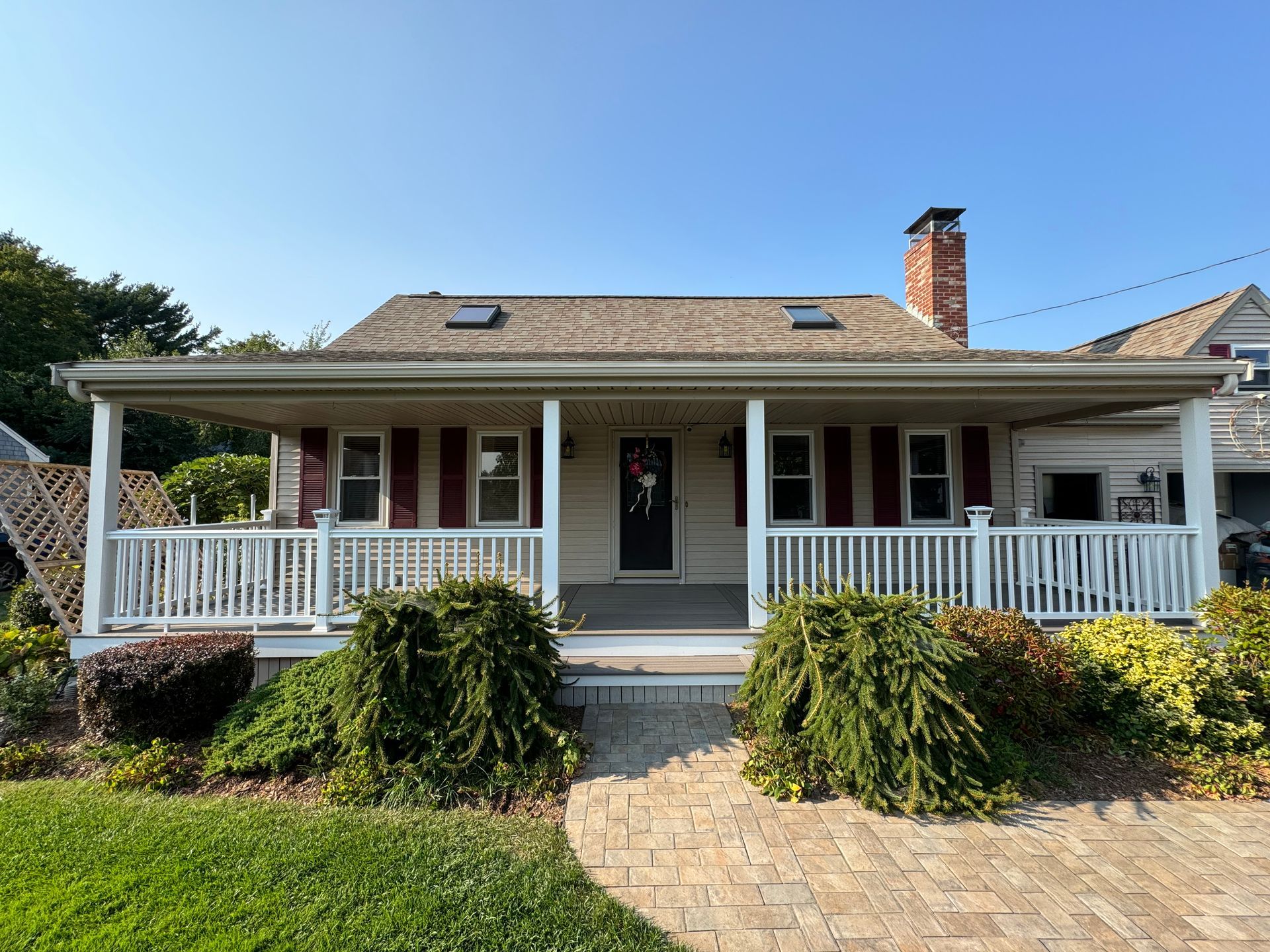 A white house with a porch and red shutters