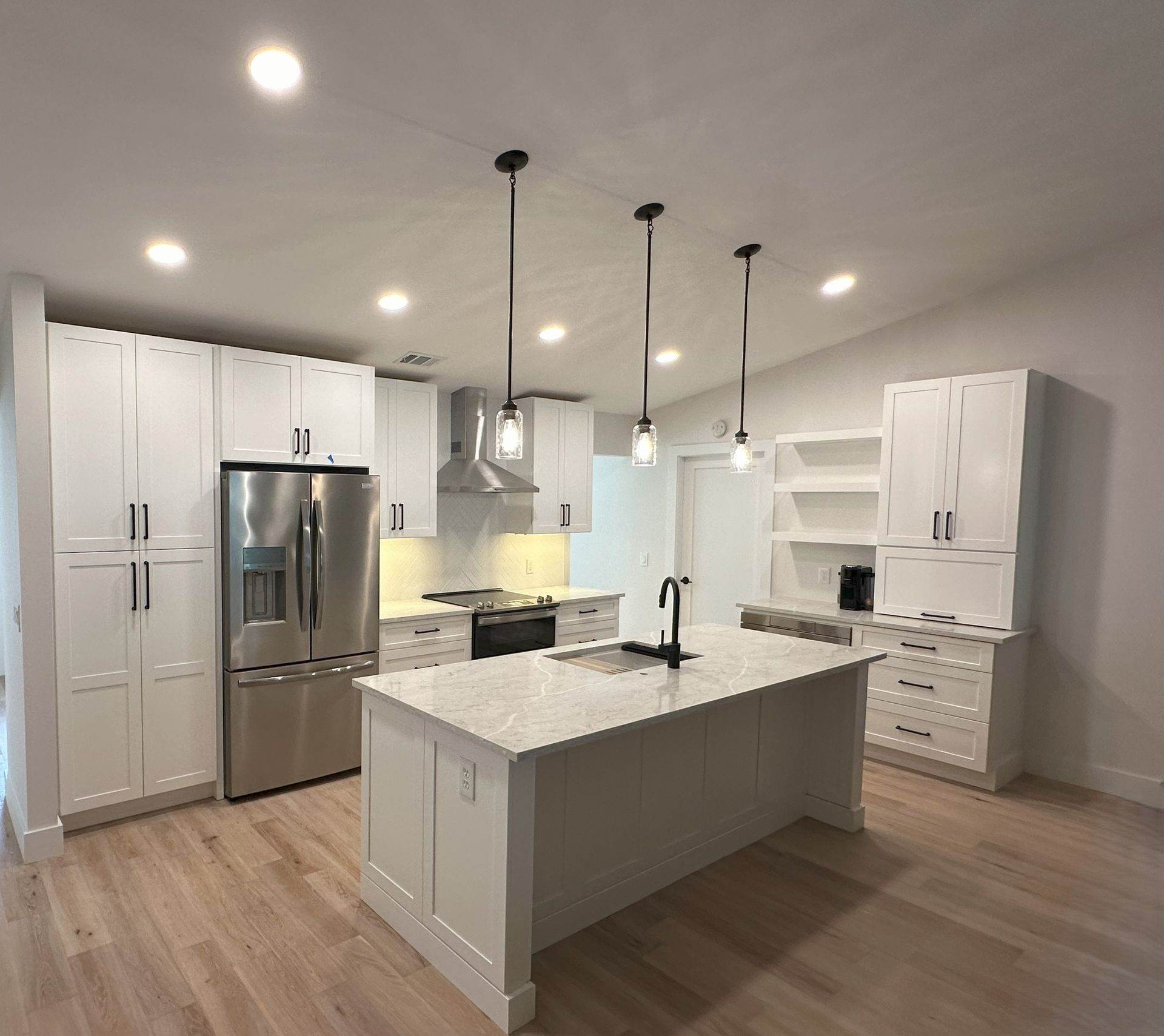 A kitchen with white cabinets and stainless steel appliances