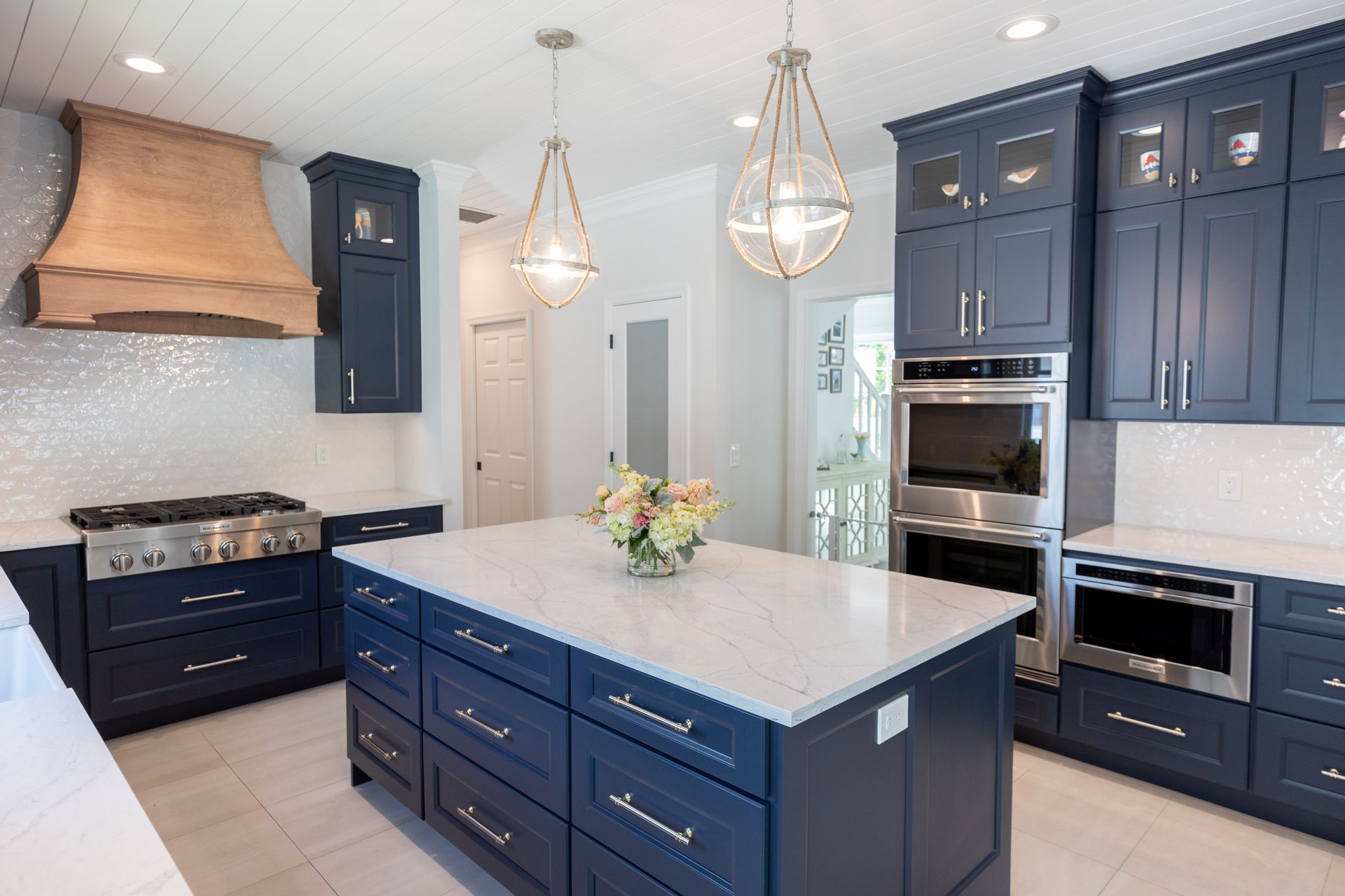 A kitchen with blue cabinets and a large island in the middle.