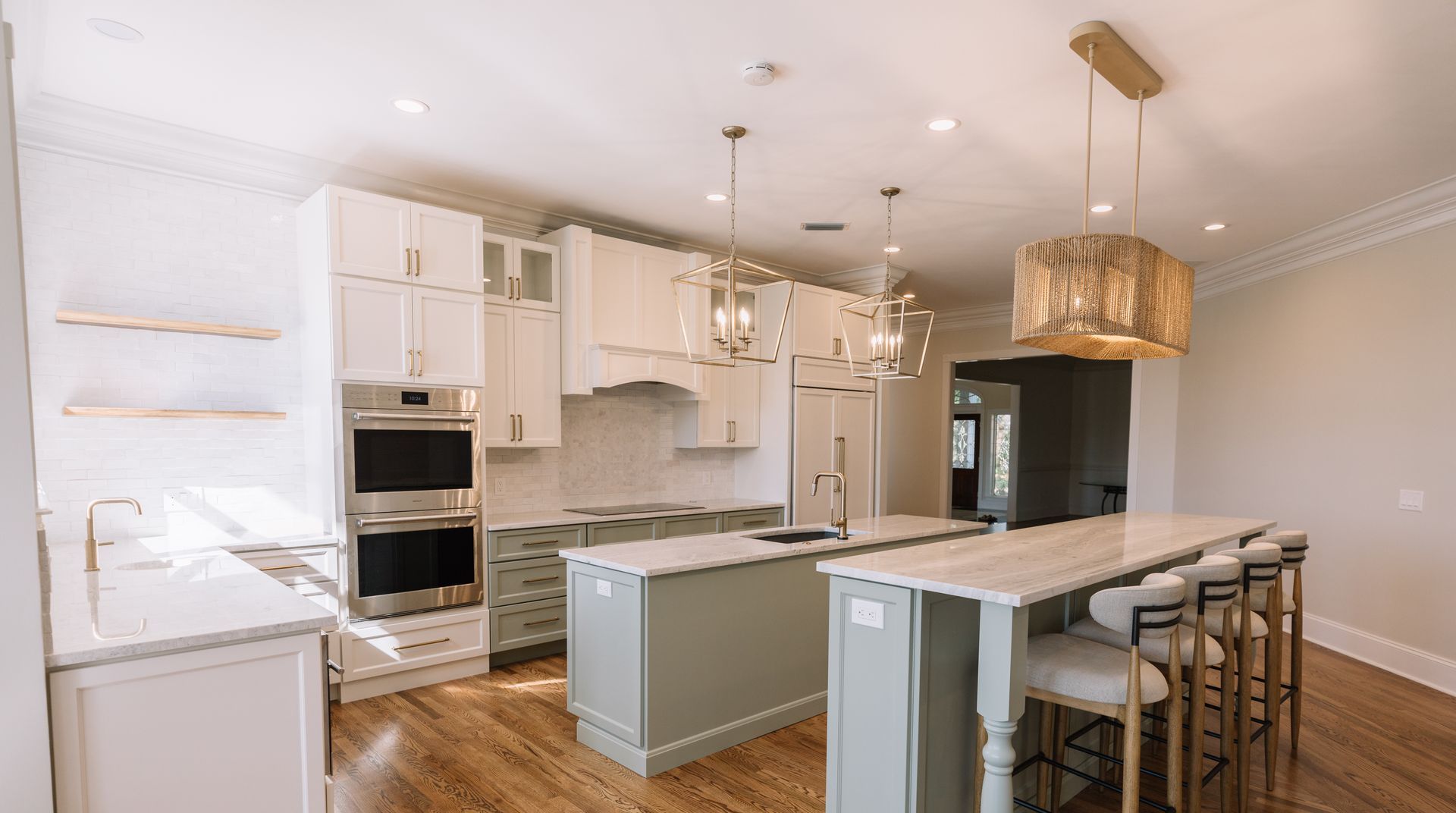 A kitchen with white cabinets , granite counter tops , stainless steel appliances and a large island.