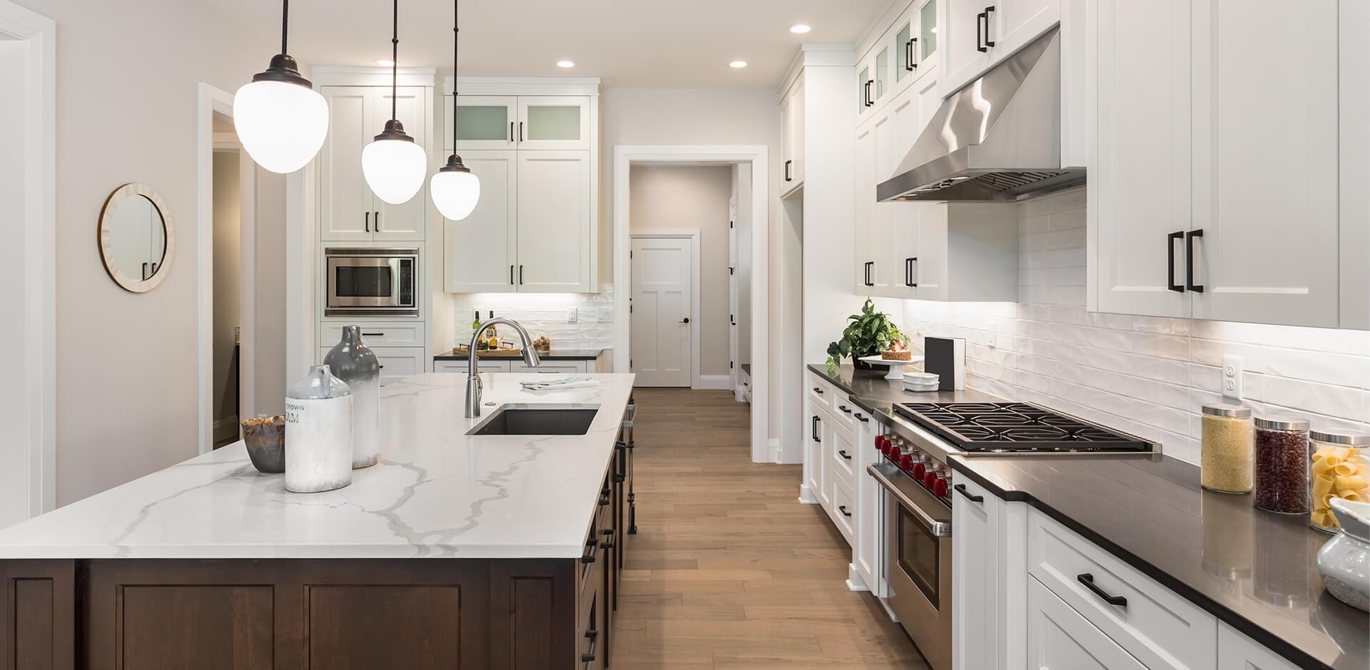 A kitchen in a new home with white cabinets and stainless steel appliances.