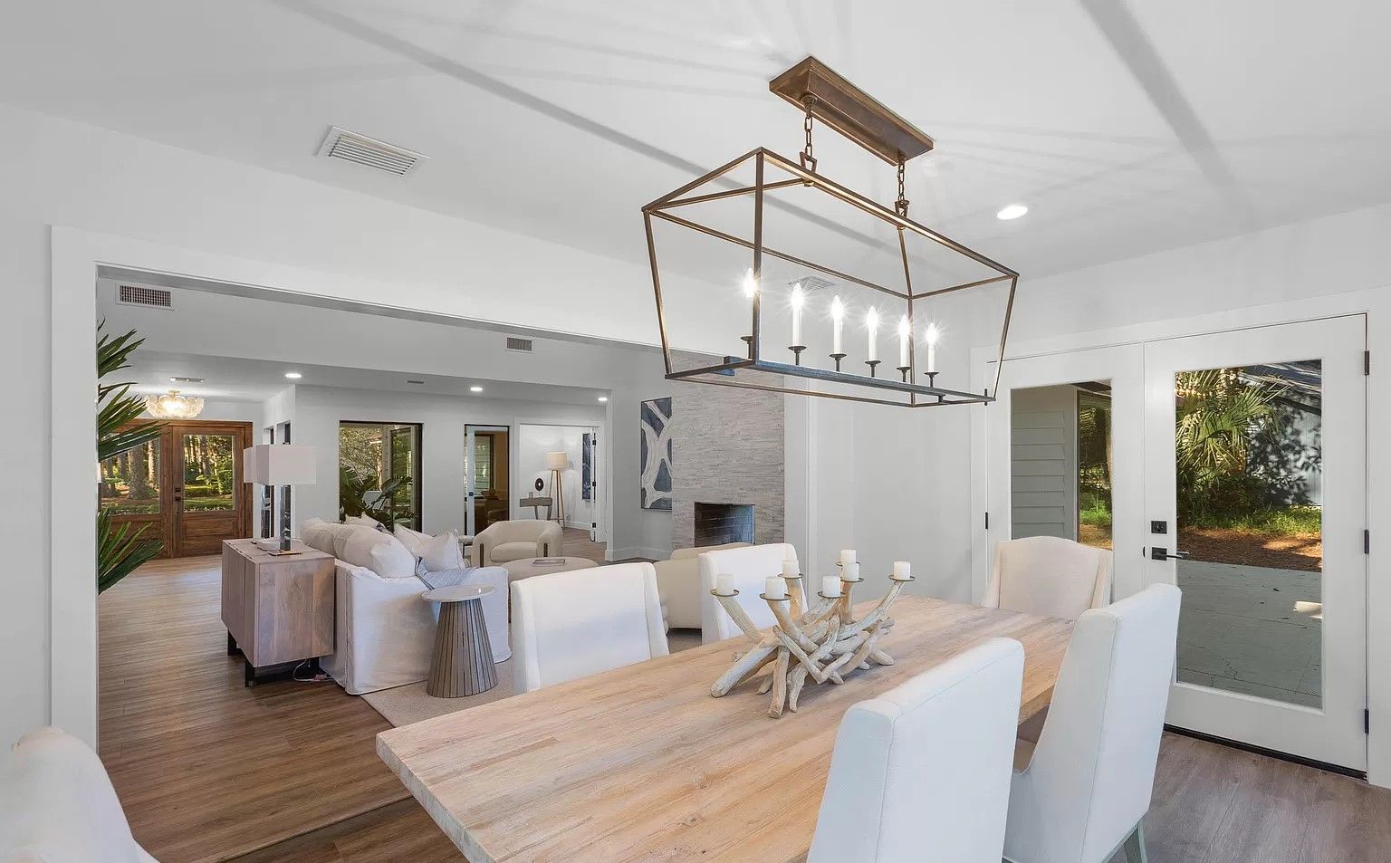 A dining room with a table and chairs and a chandelier hanging from the ceiling.