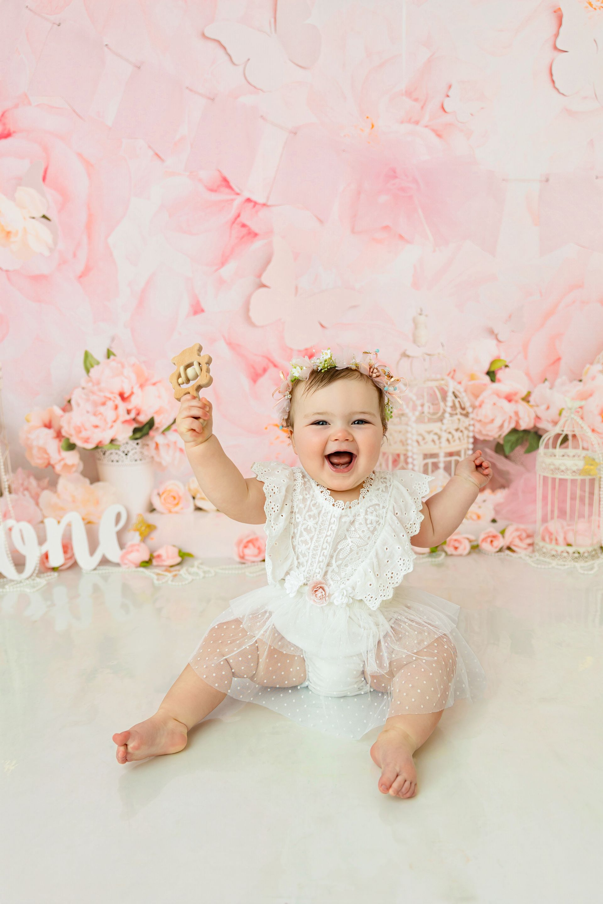 Baby girl cake smash with soft florals and natural expressions in Cary studio