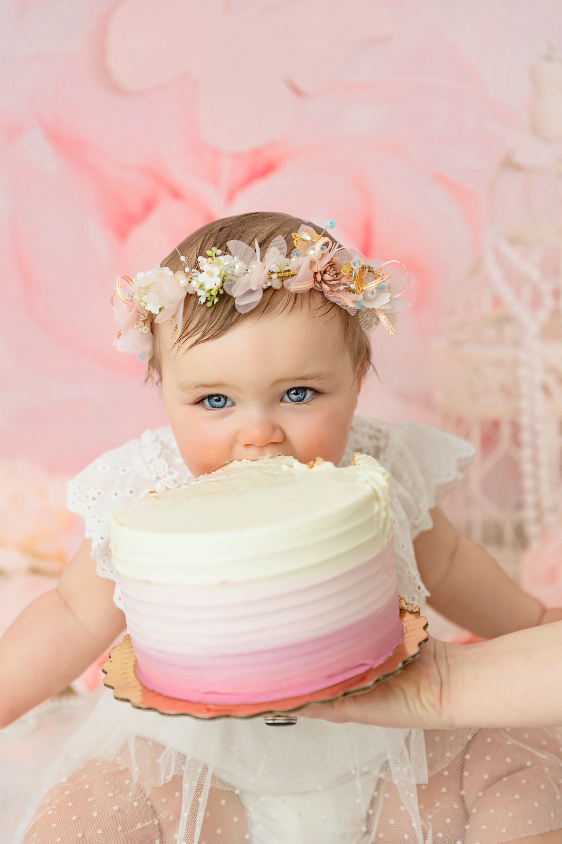 Happy baby girl celebrating first birthday cake smash in Cary studio