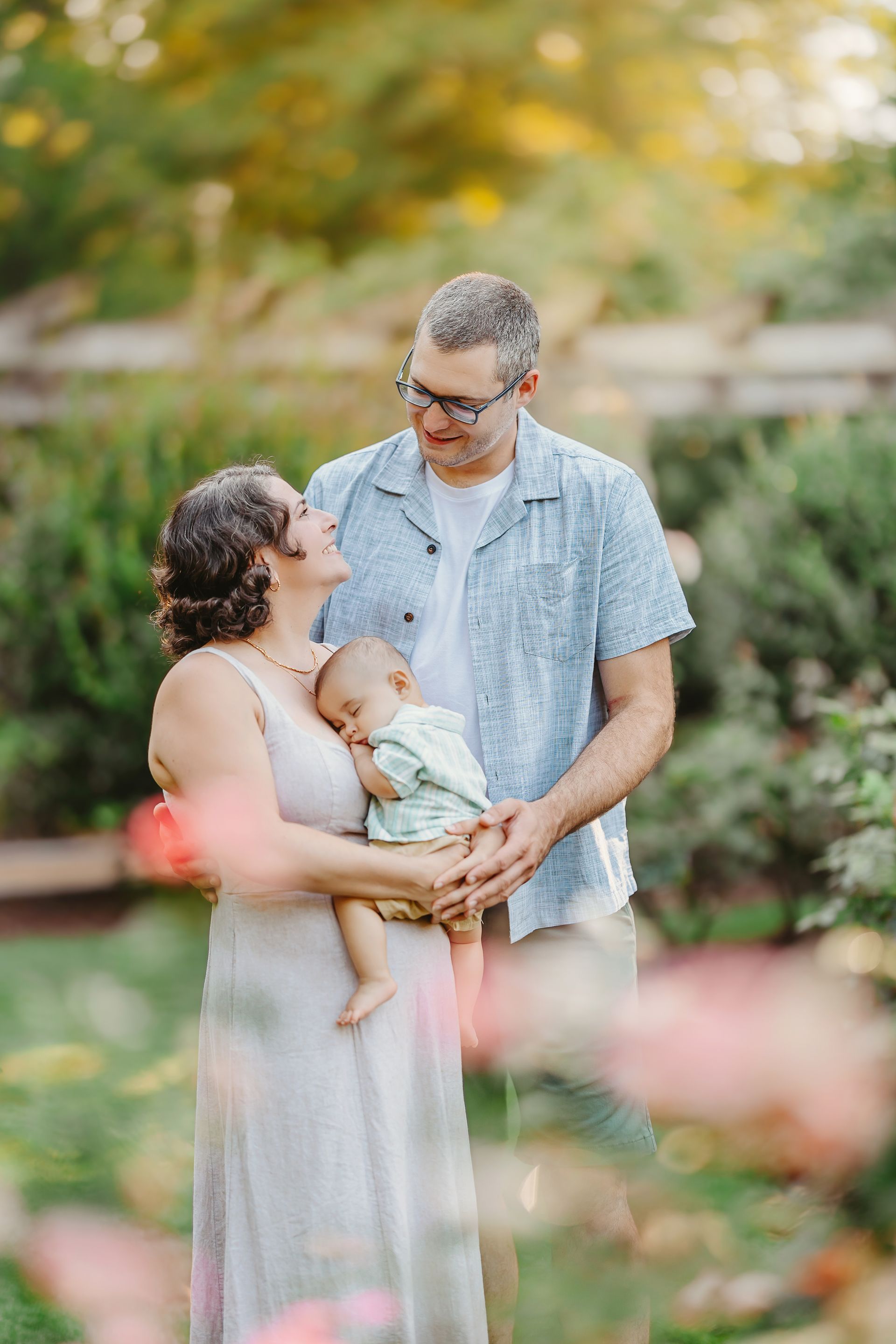 Mother, Father and baby peacefully sleeping during the morning portrait session at the Raleigh Rose Garden