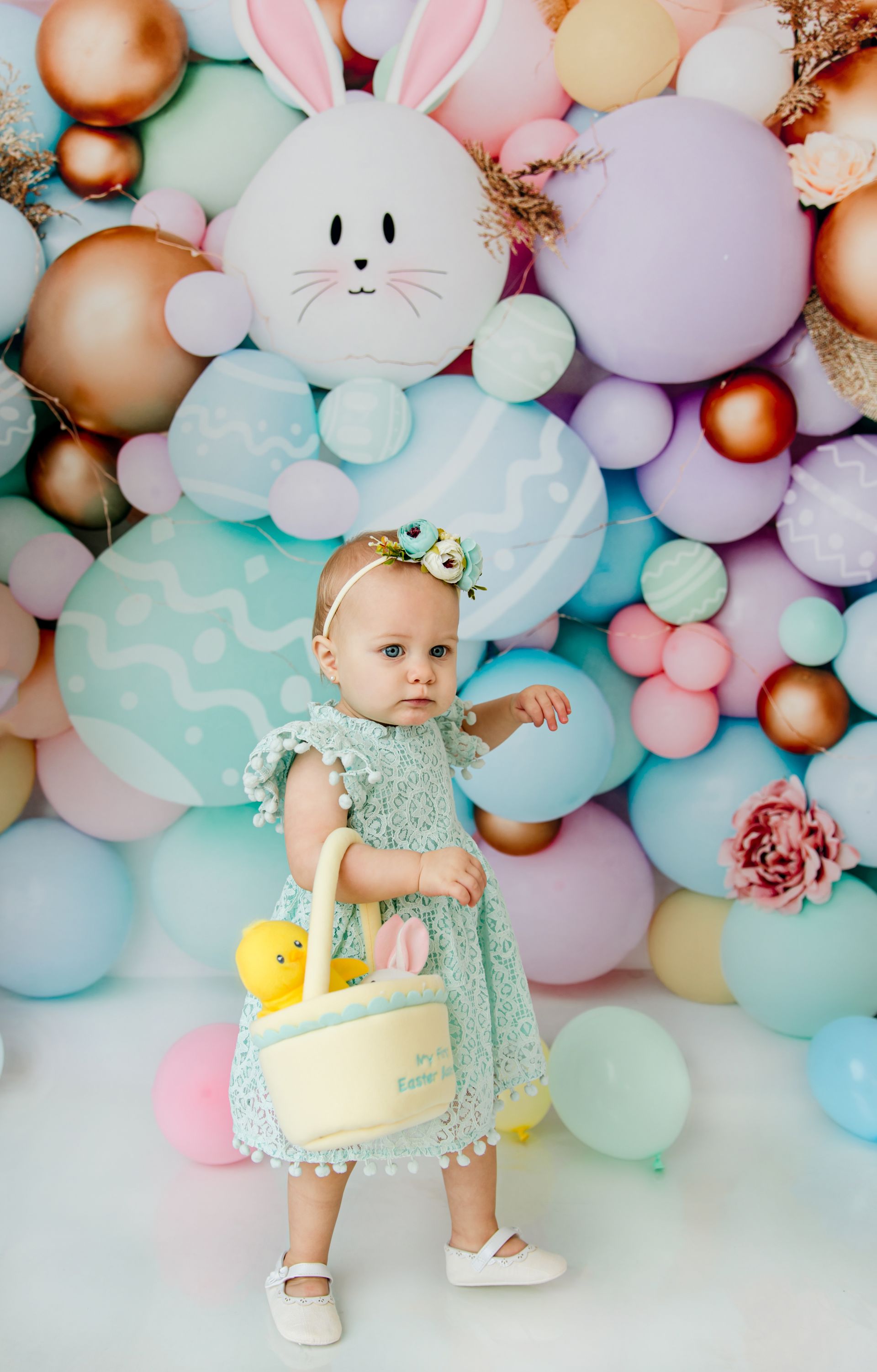 Little girl holding Easter eggs in hand during studio session in Cary NC