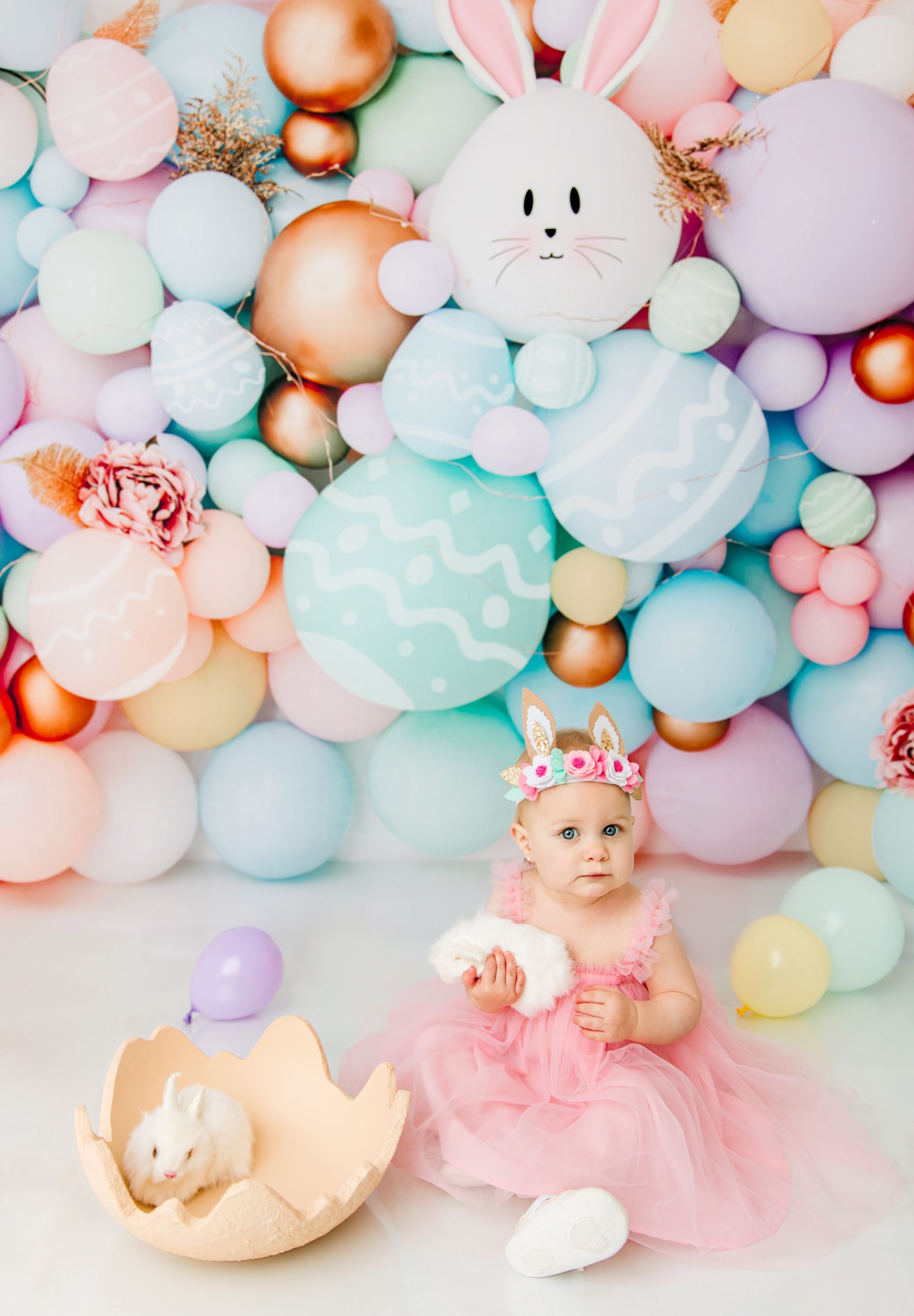 toddler girl in soft pink dress posing Easter bunny prop studio photography in Cary NC