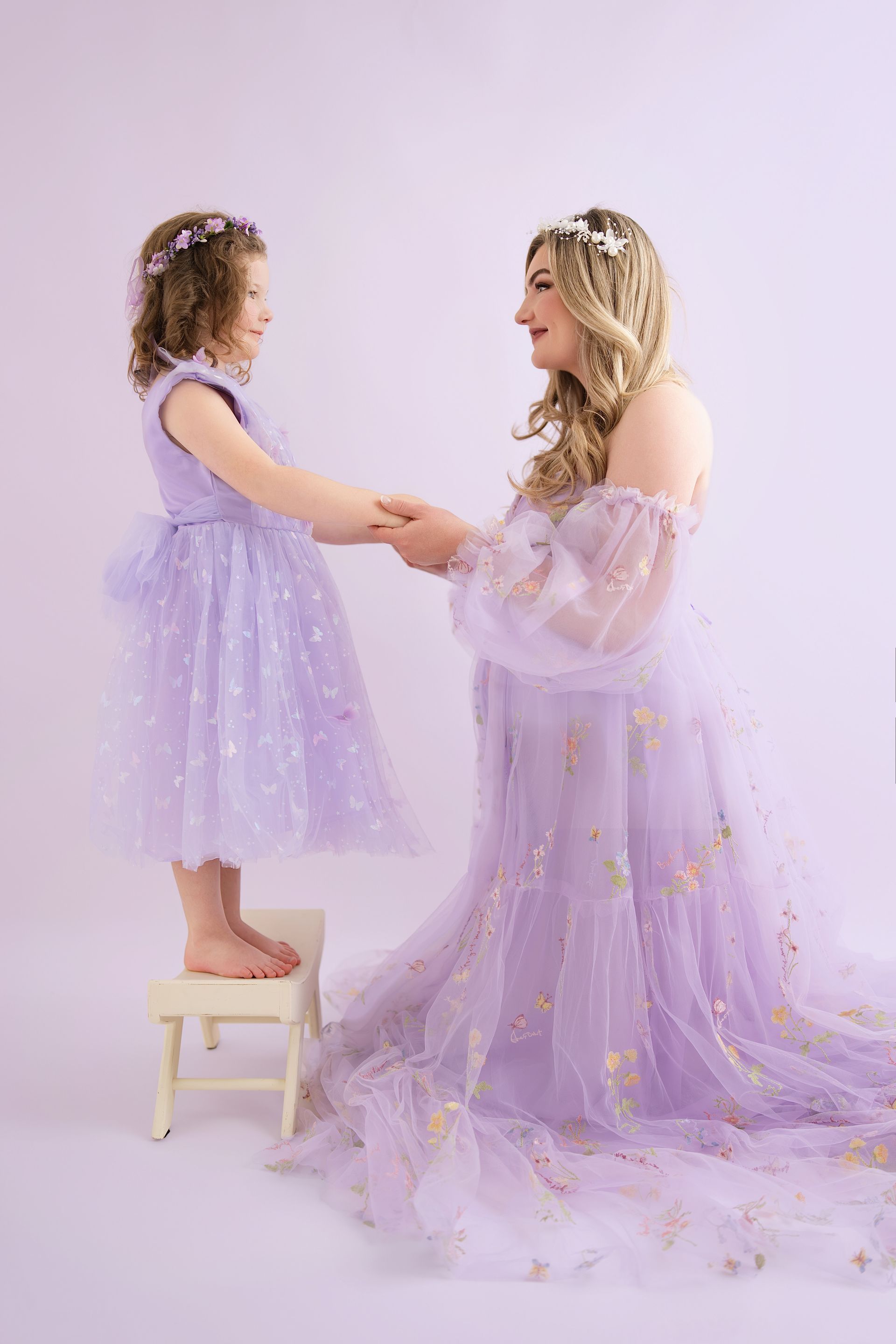Mother and daughter playing together in a joyful studio maternity session