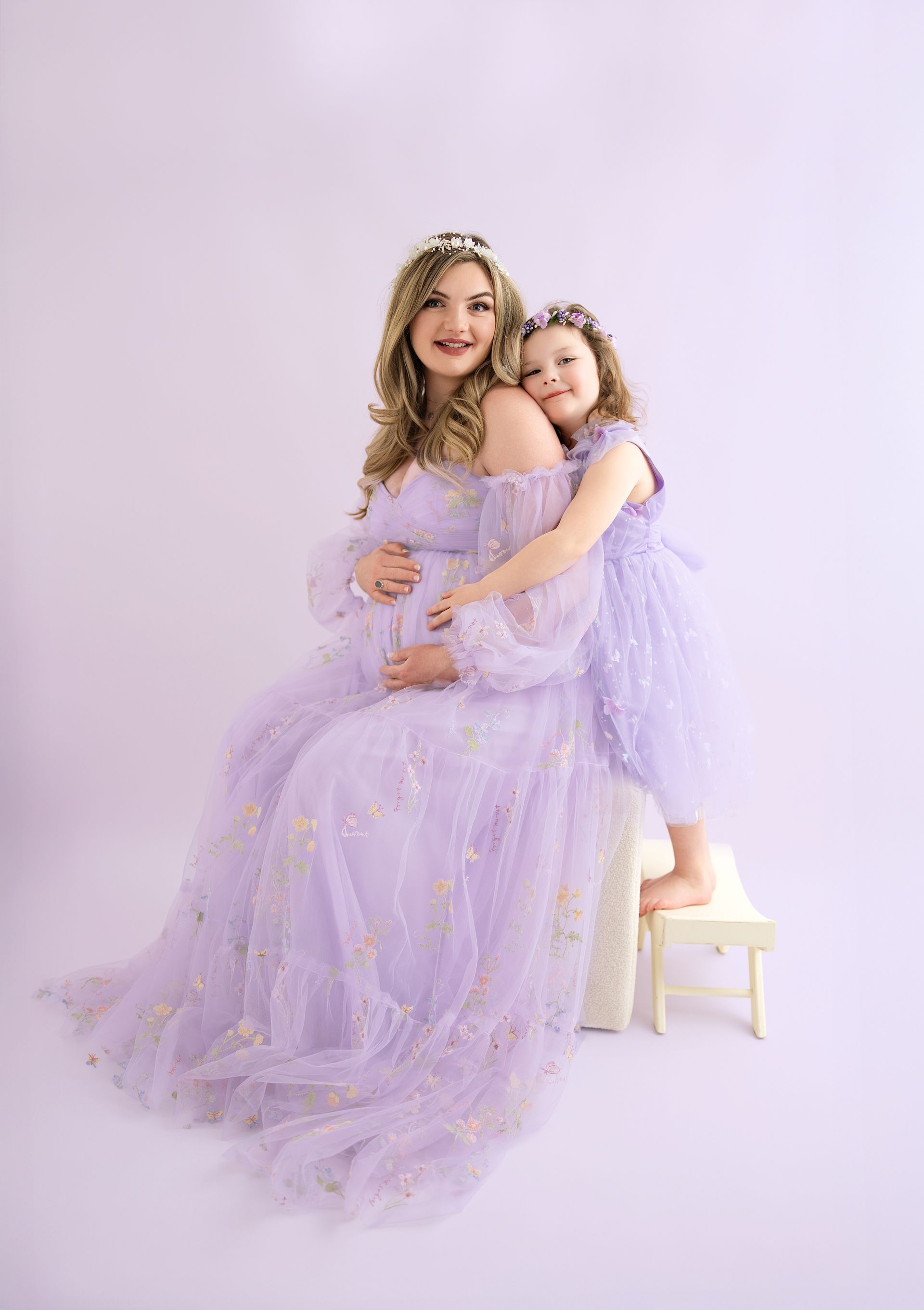 Pregnant mother hugging her 4-year-old daughter before baby sister’s arrival