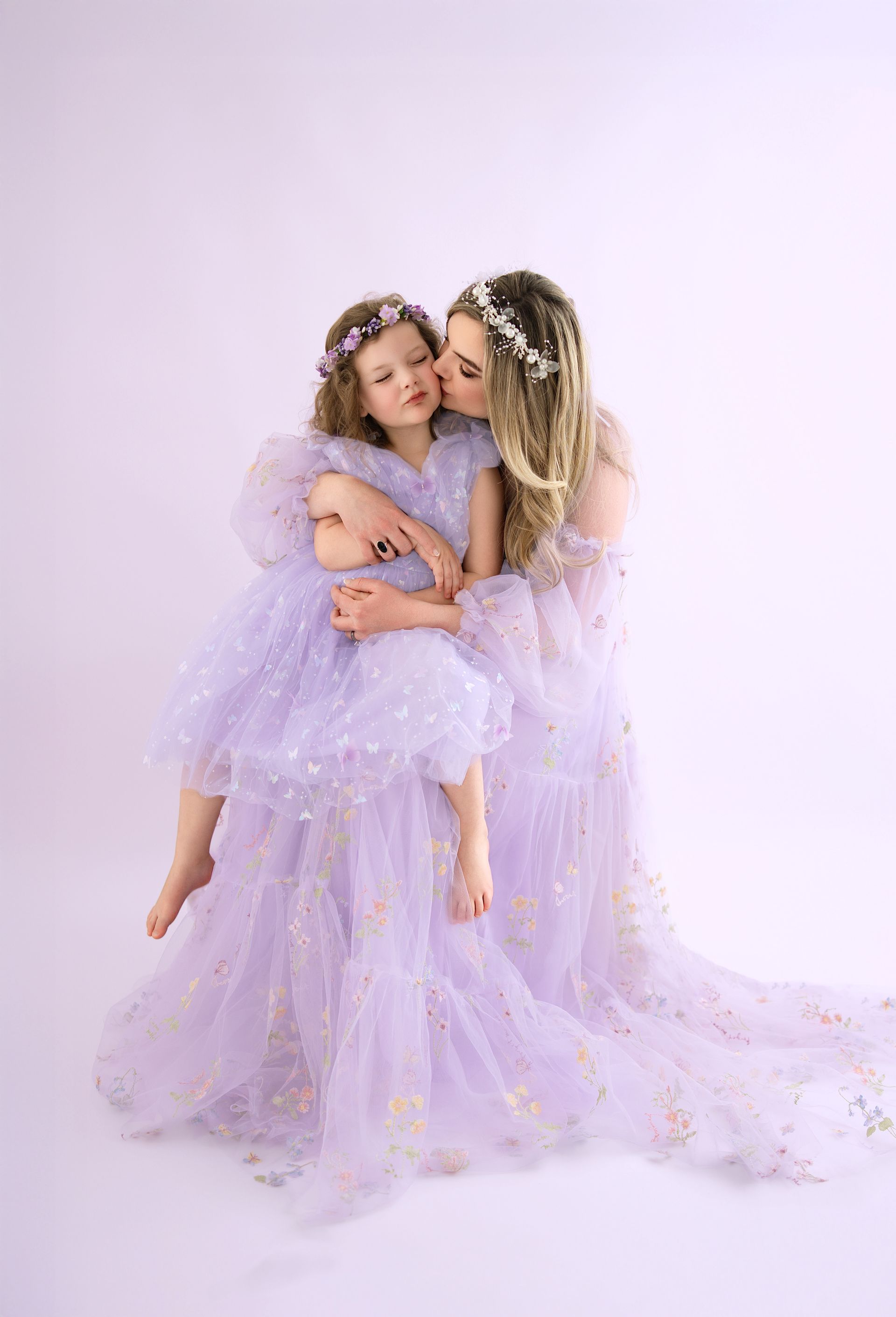 Mother and daughter looking at each other during a purple-themed maternity and milestone studio session