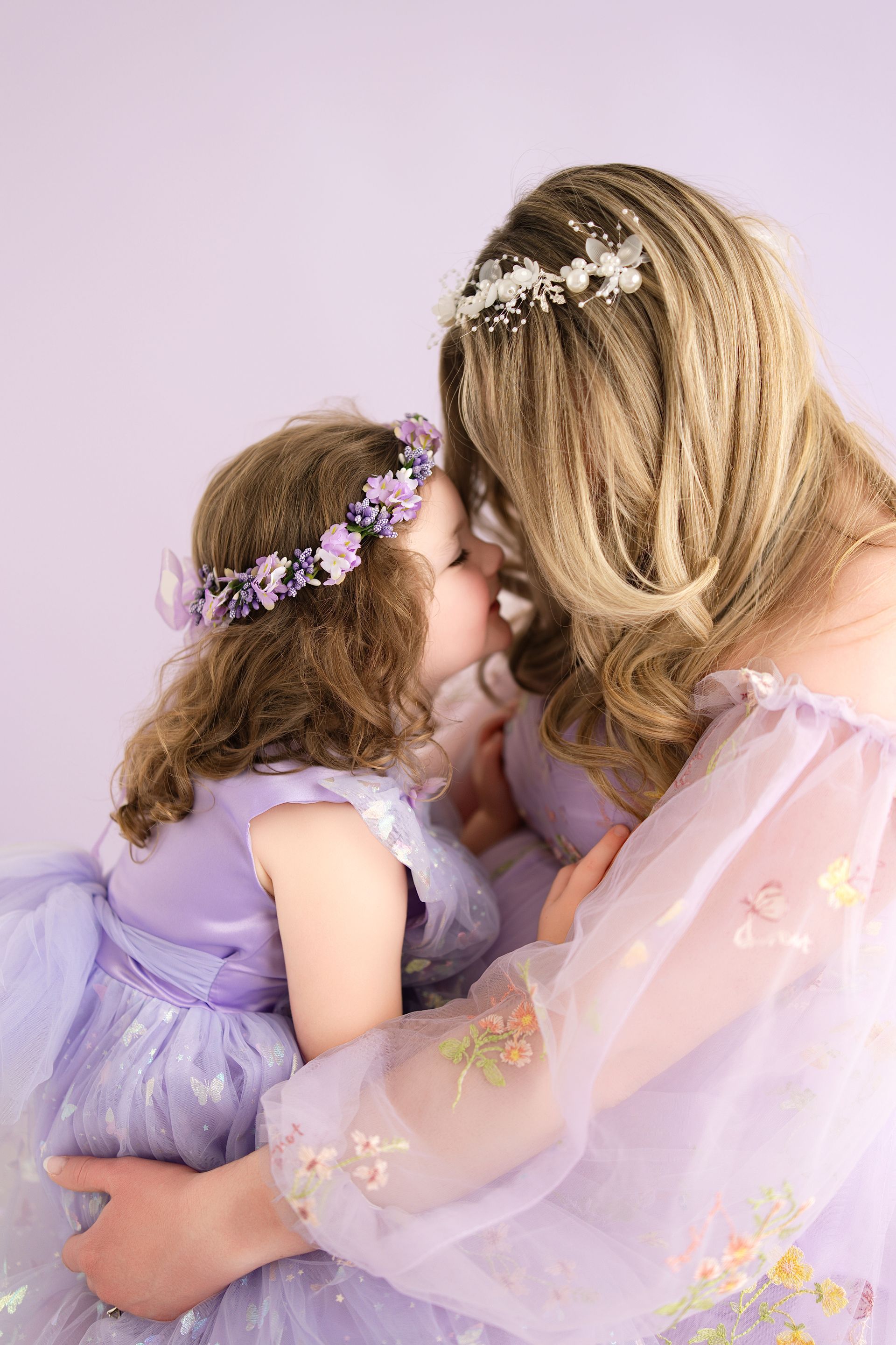 Mother and daughter hugging in a purple-themed studio session before baby sister arrives