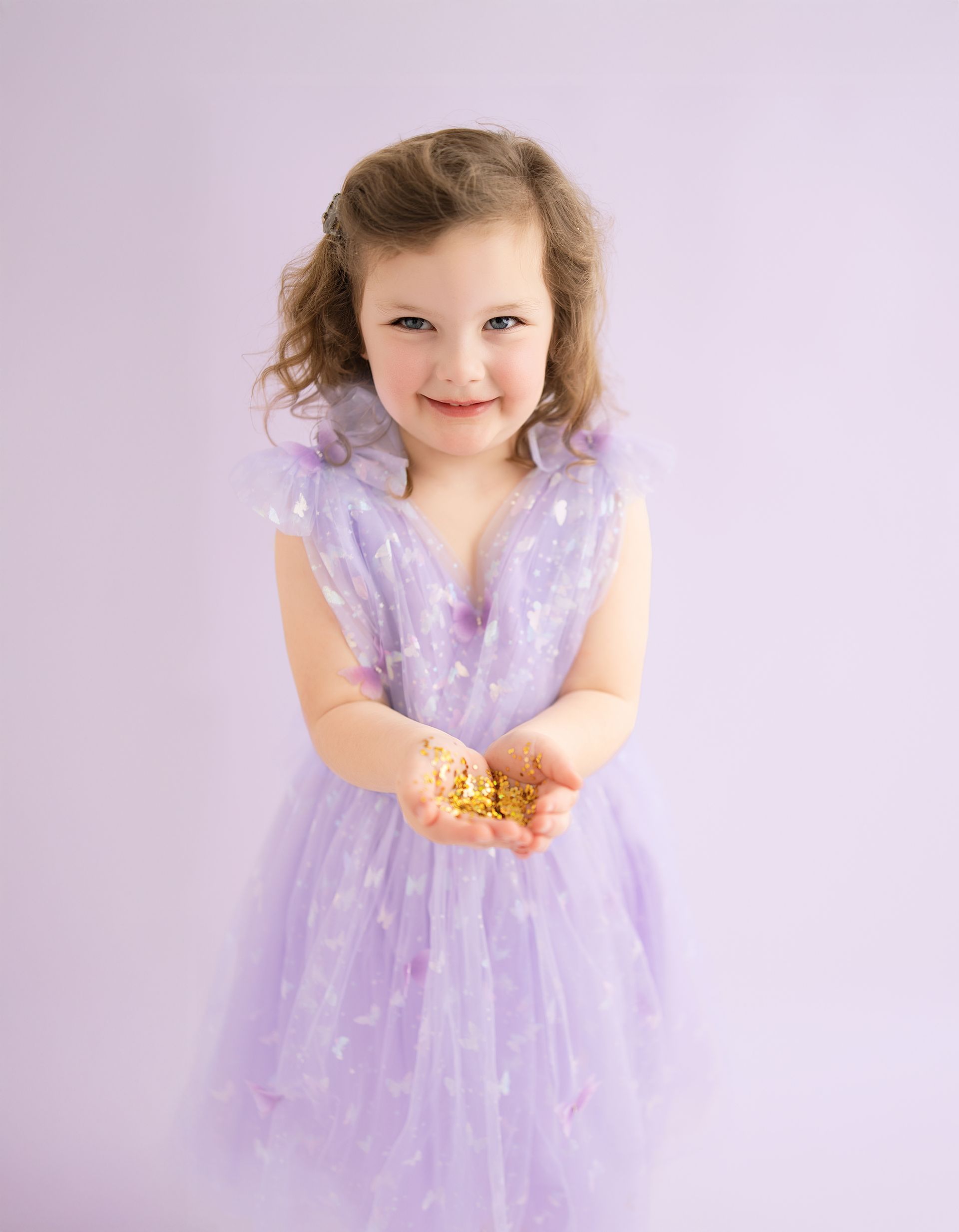 4-year-old girl holding glitter during magical studio birthday session