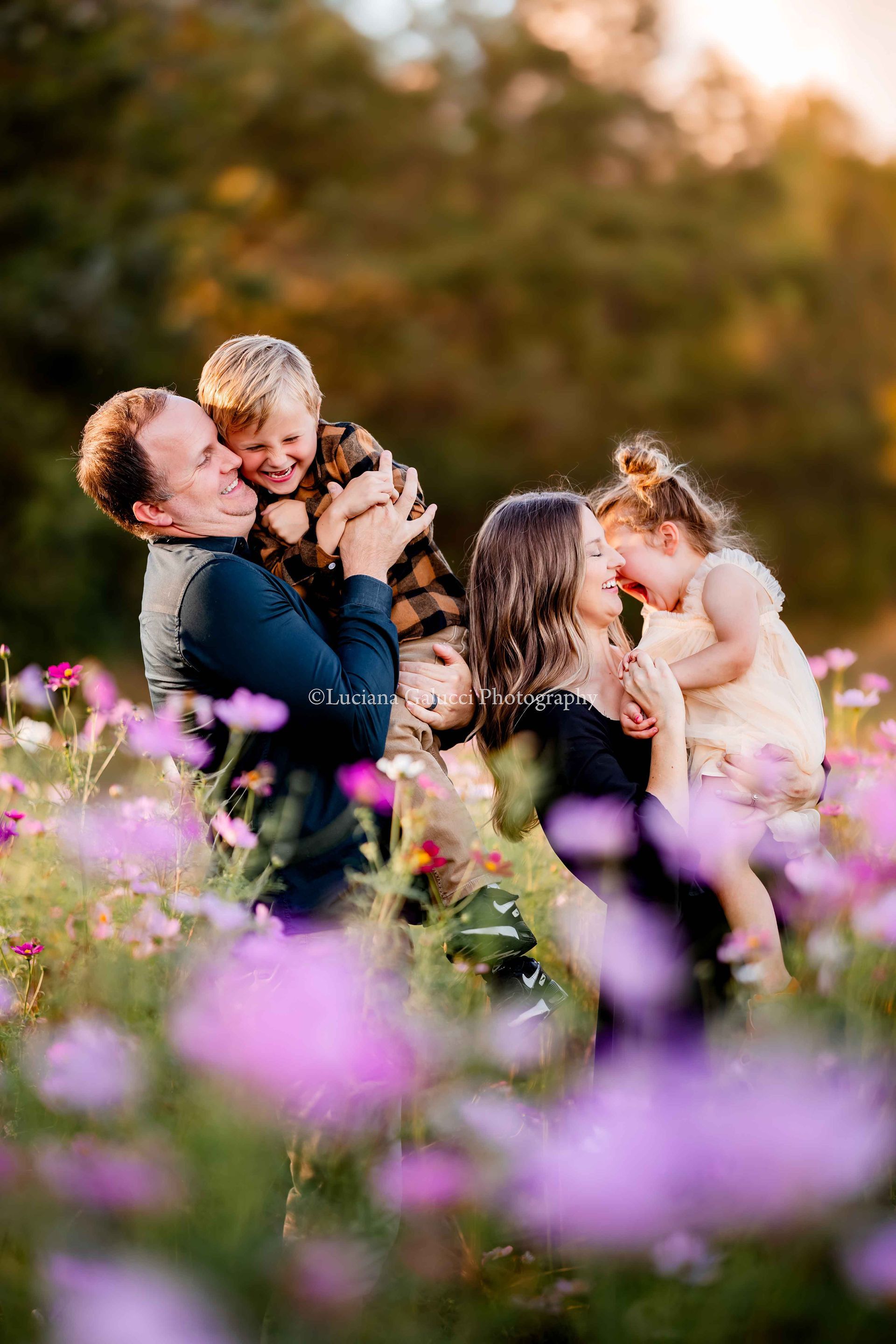Happy family with mom, dad, and siblings enjoying a golden hour photo session in a flower field in R