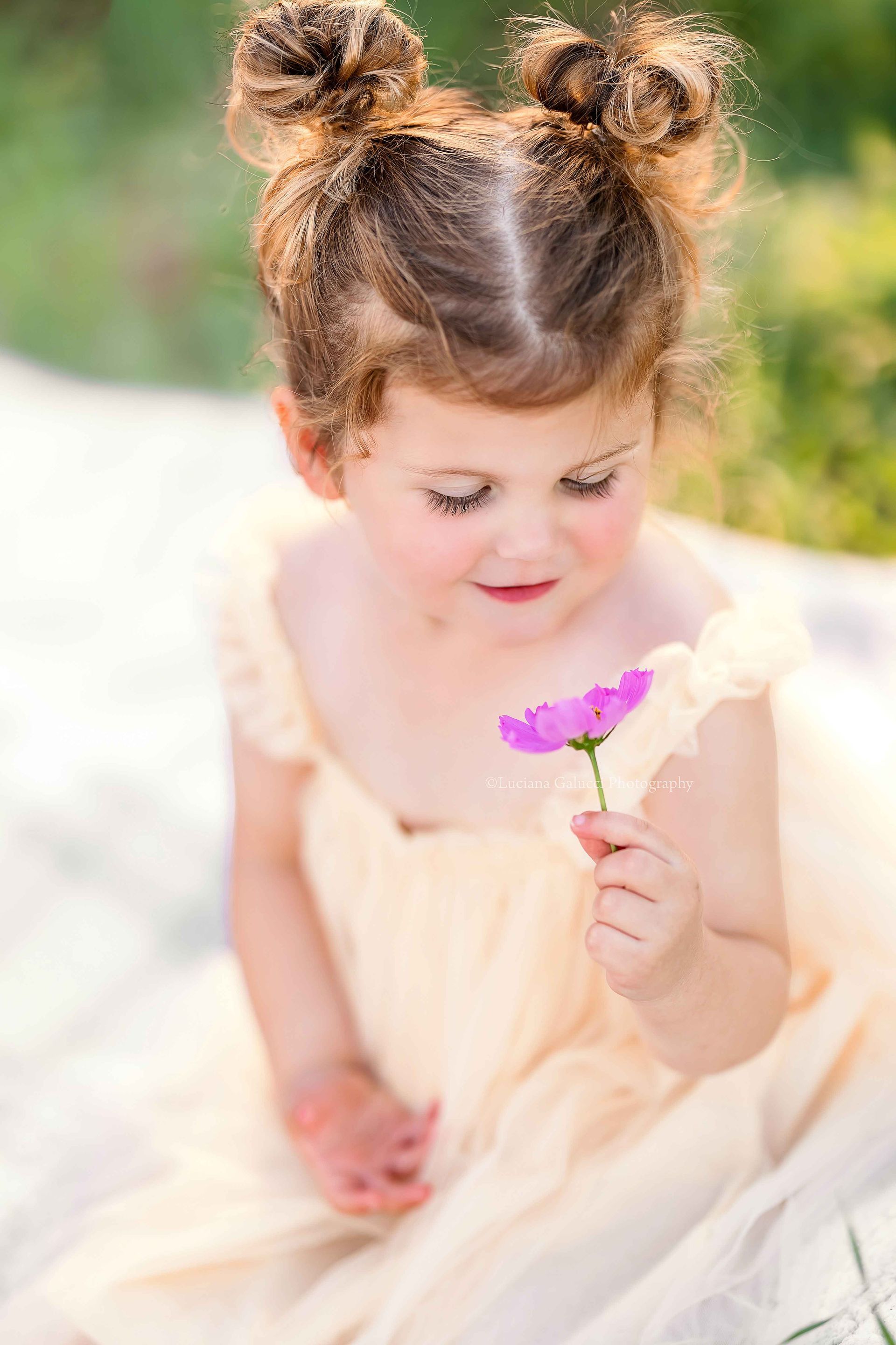 Happy toddler girl enjoying a golden hour photo session in a flower field in Raleigh