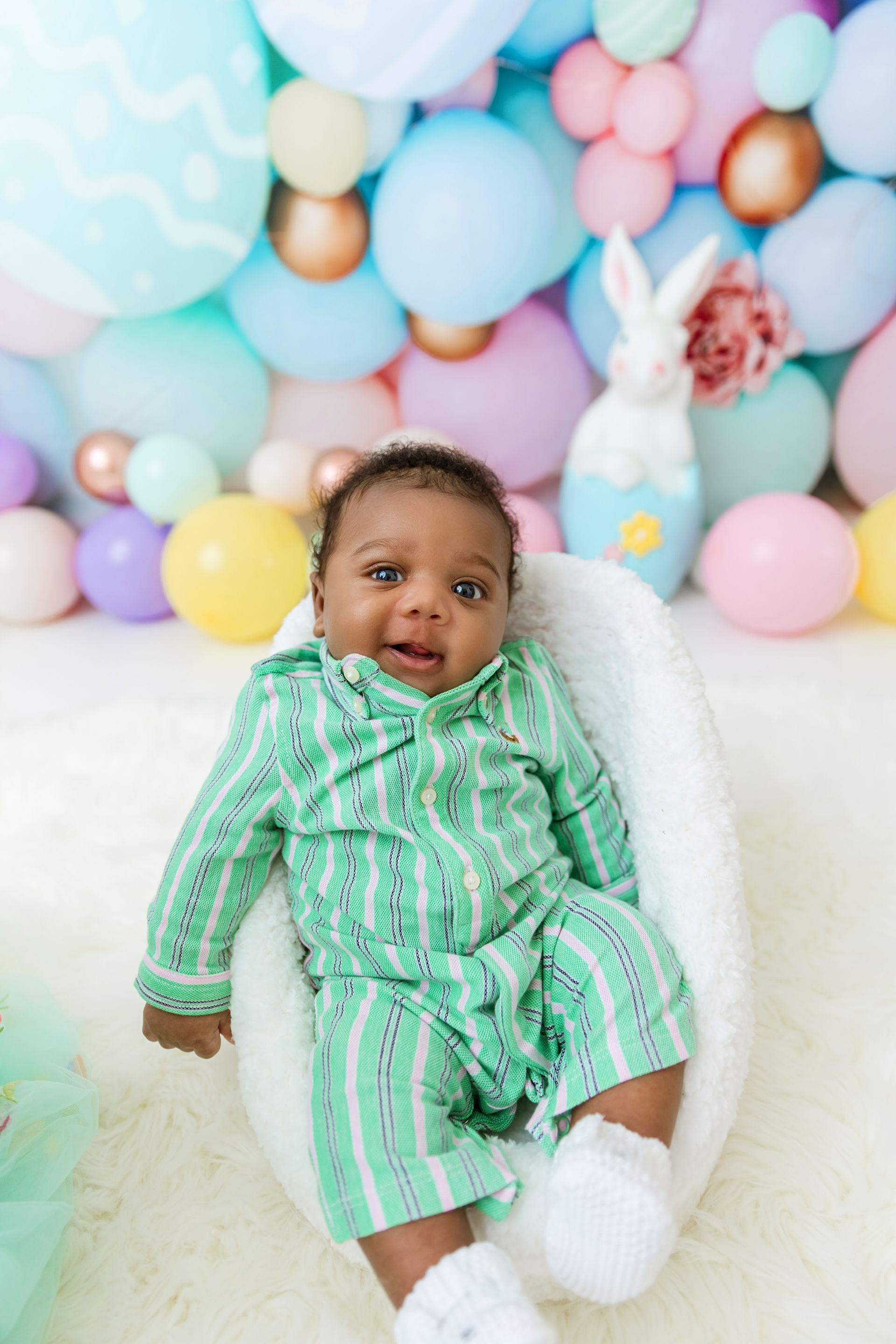 Smiling baby during Easter mini session with pastel balloon backdrop in Cary NC studio