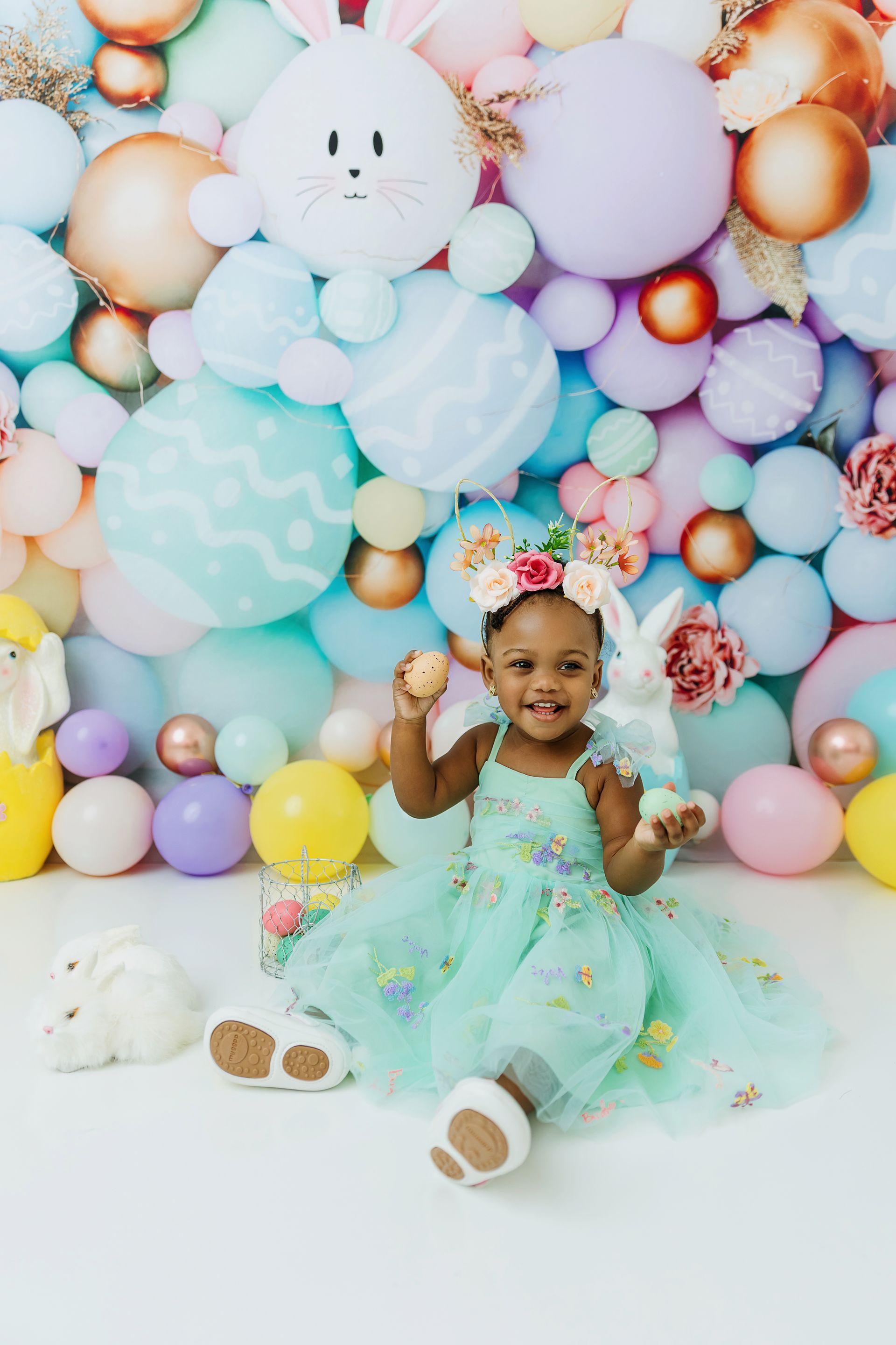 Toddler girl smiling and playing with easter eggs during her easter session in Cary NC