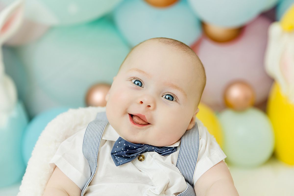 Smiling baby during Easter mini session with pastel balloon backdrop in Cary NC studio