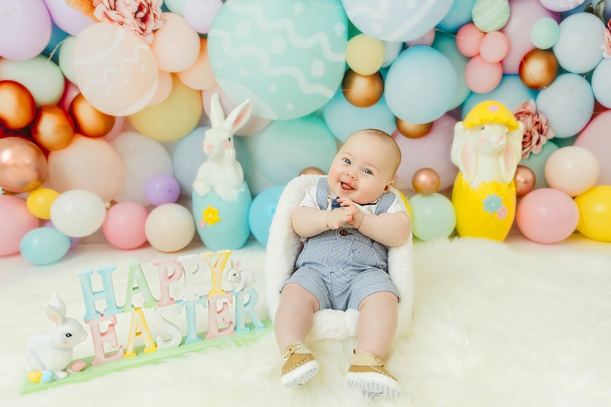 Baby boy smiling Easter mini session in pastel studio setup in Cary NC
