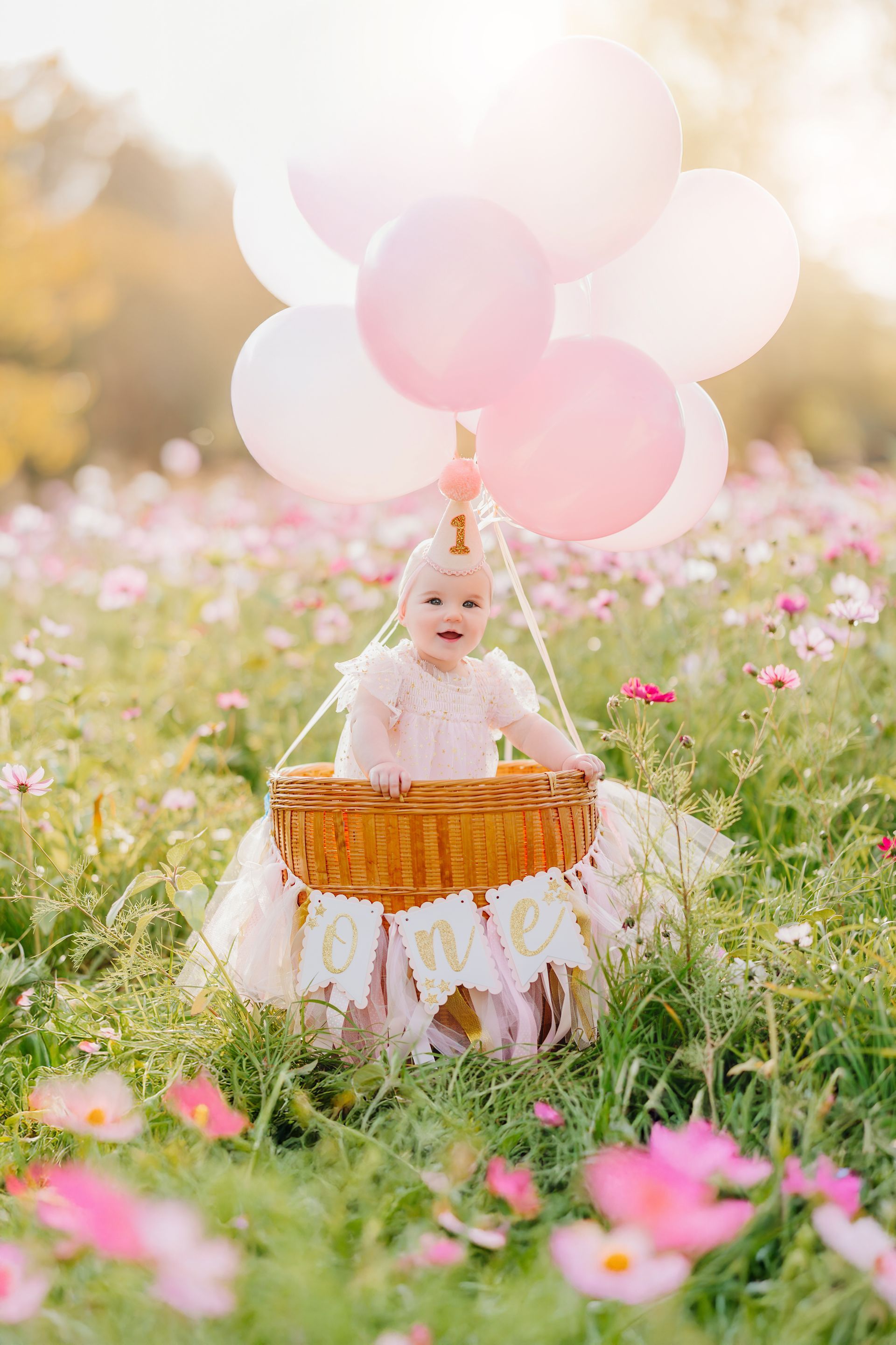 One year old portraitswith pink balloons at a Flower field in Raleigh NC
