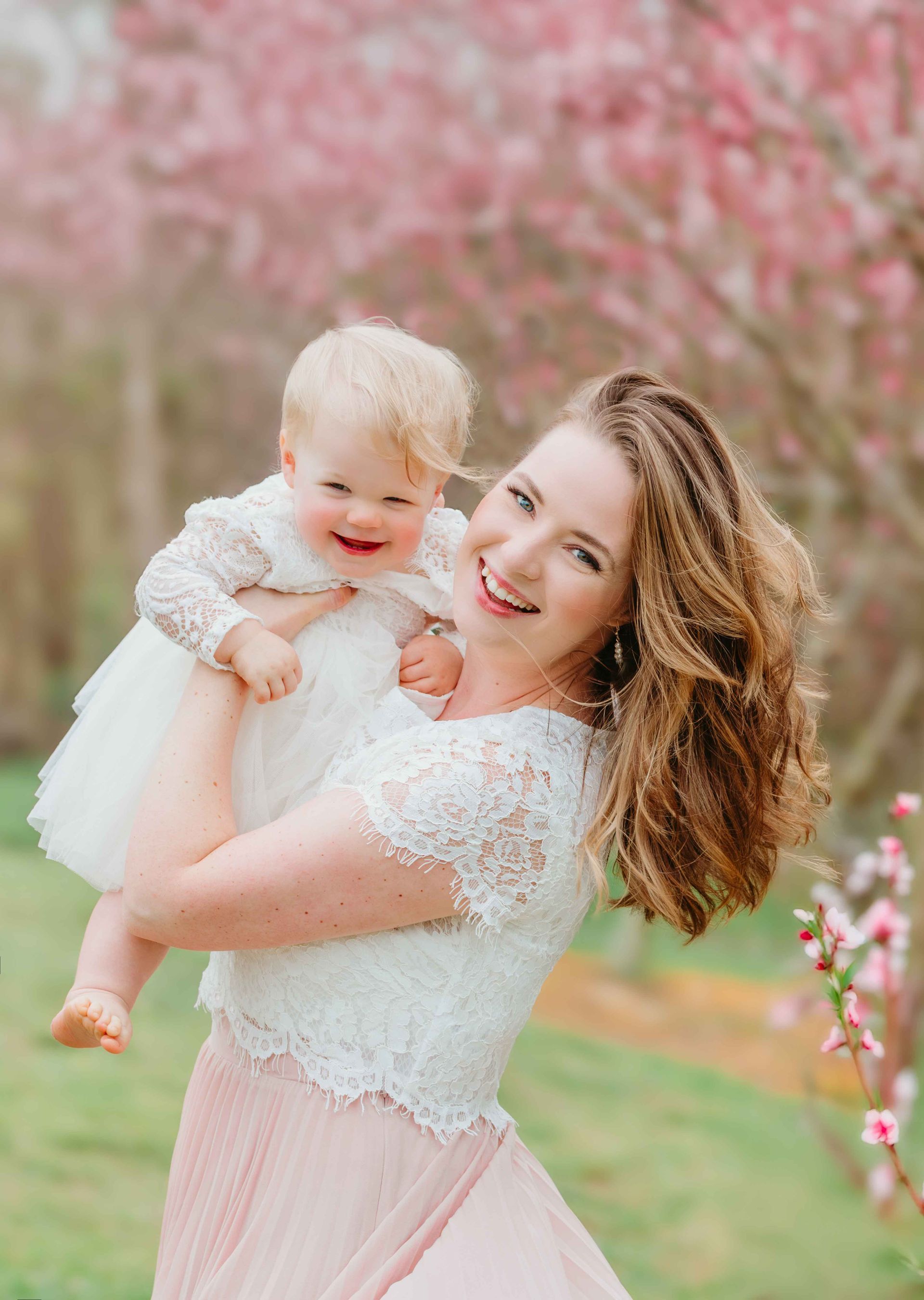Mother and Daughter smiling at the peach blossoms blooms