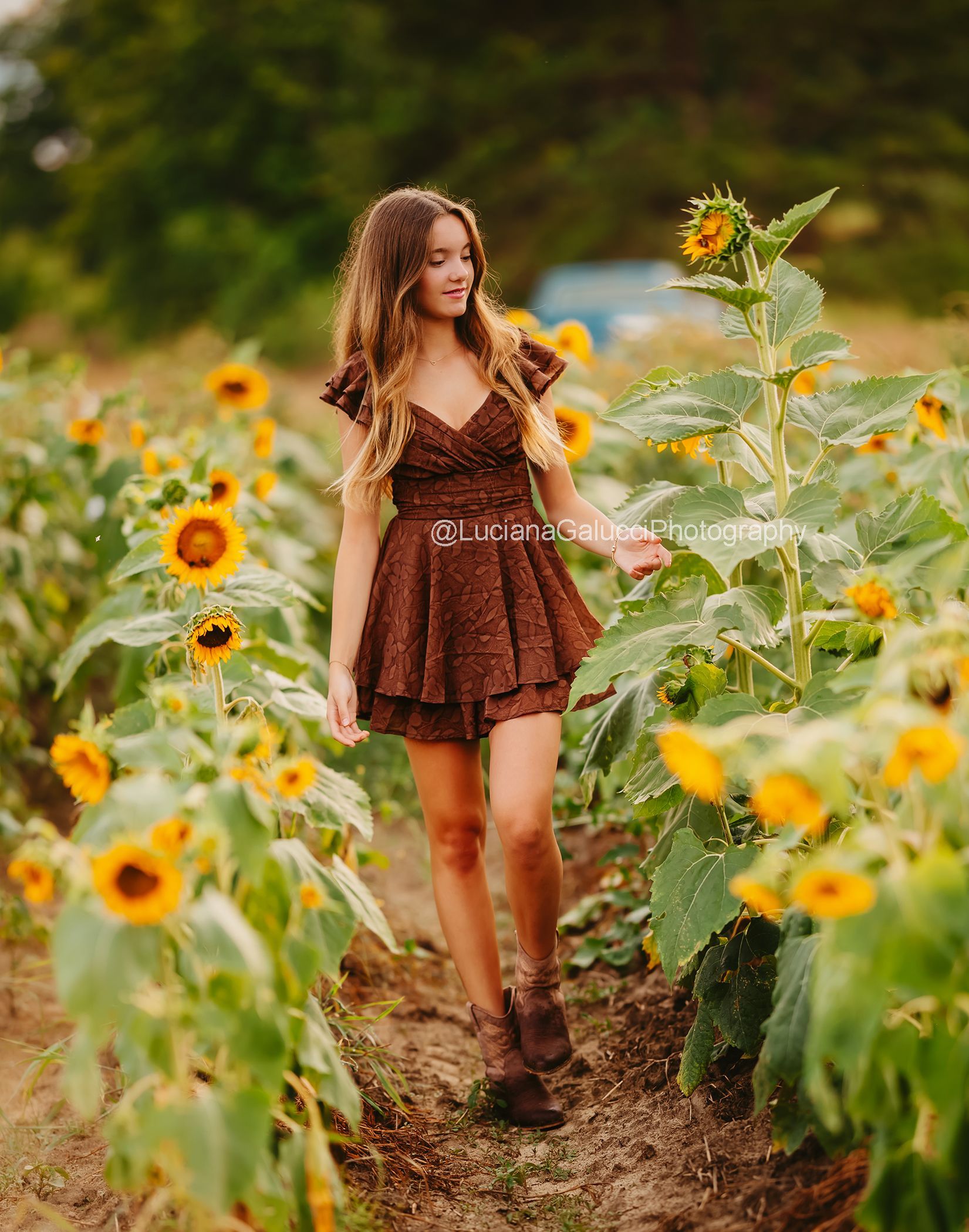 Candid portrait of a teenage girl in a sunflower field near Raleigh.
