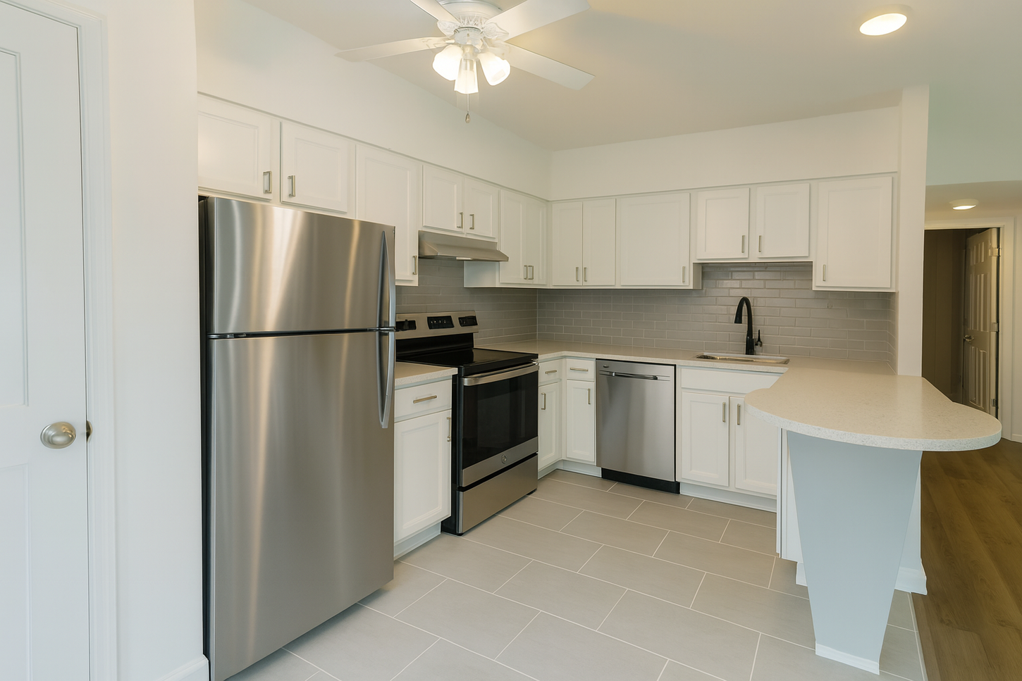 White kitchen with stainless steel appliances, white cabinets, and gray tile flooring.