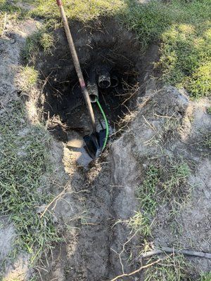 A shovel is sitting in the middle of a hole in the ground.