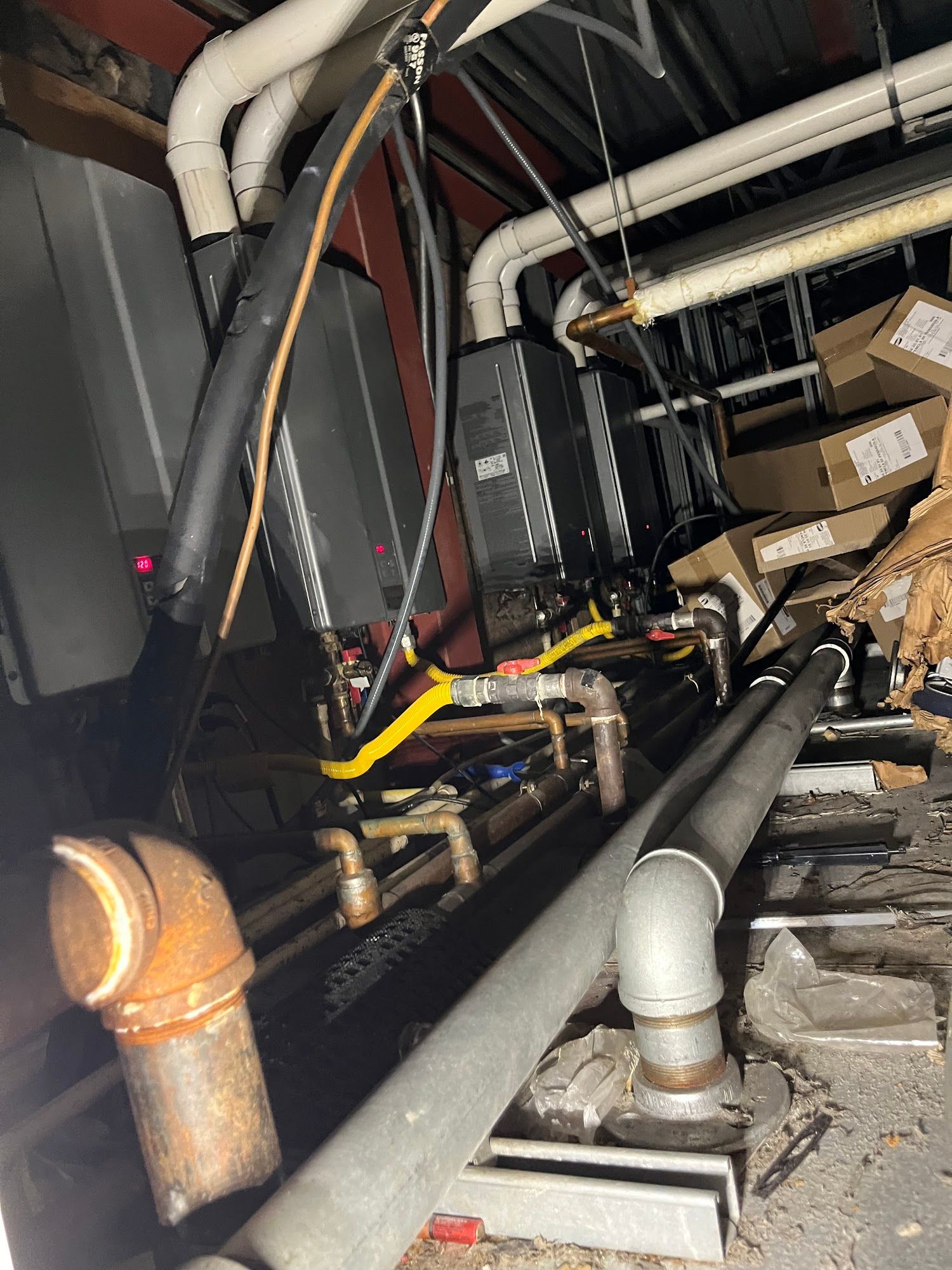 A bunch of pipes are hanging from the ceiling in a room.