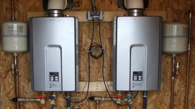 Two water heaters are hanging on a wall next to each other.